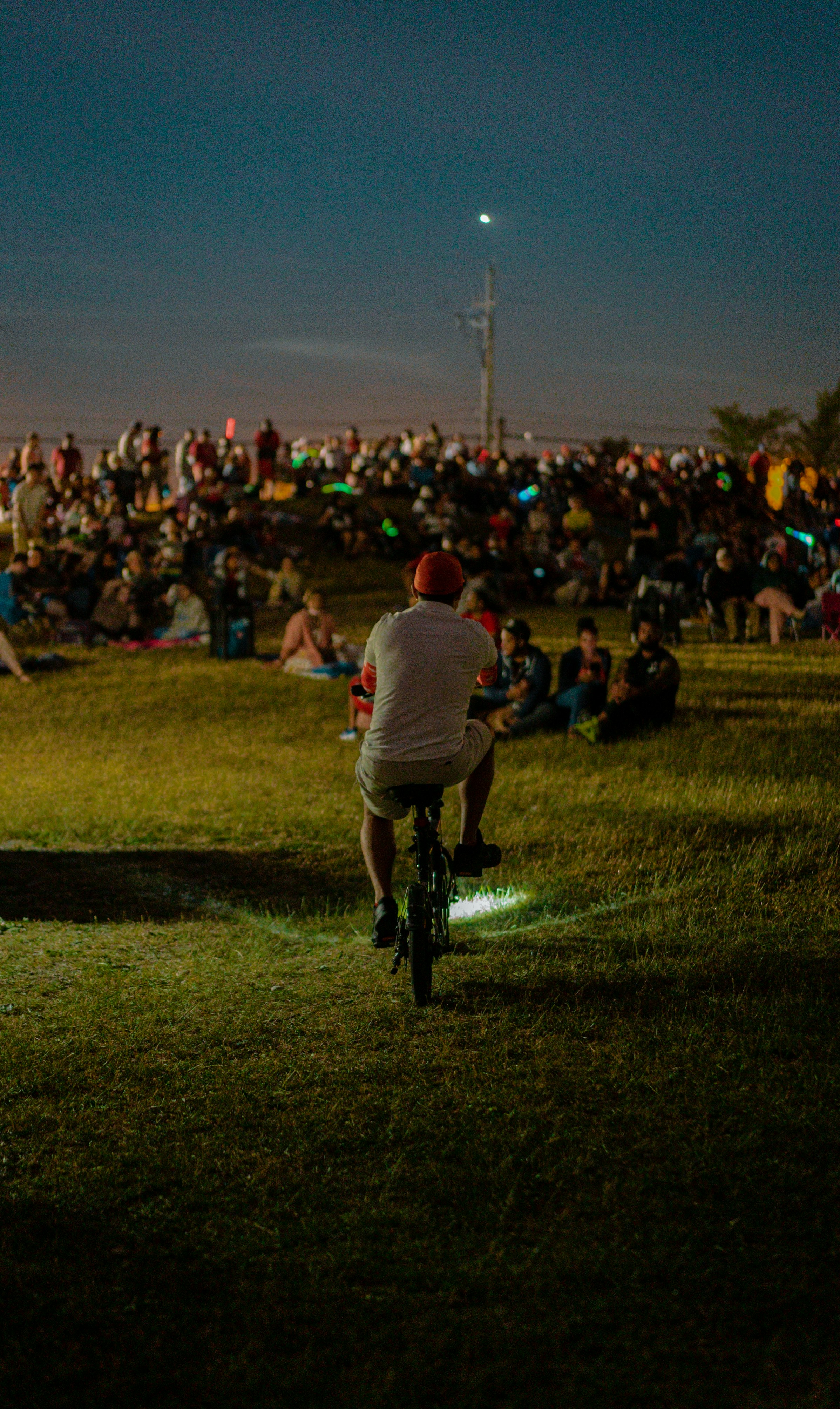 A man riding a bike in front of a crowd of people