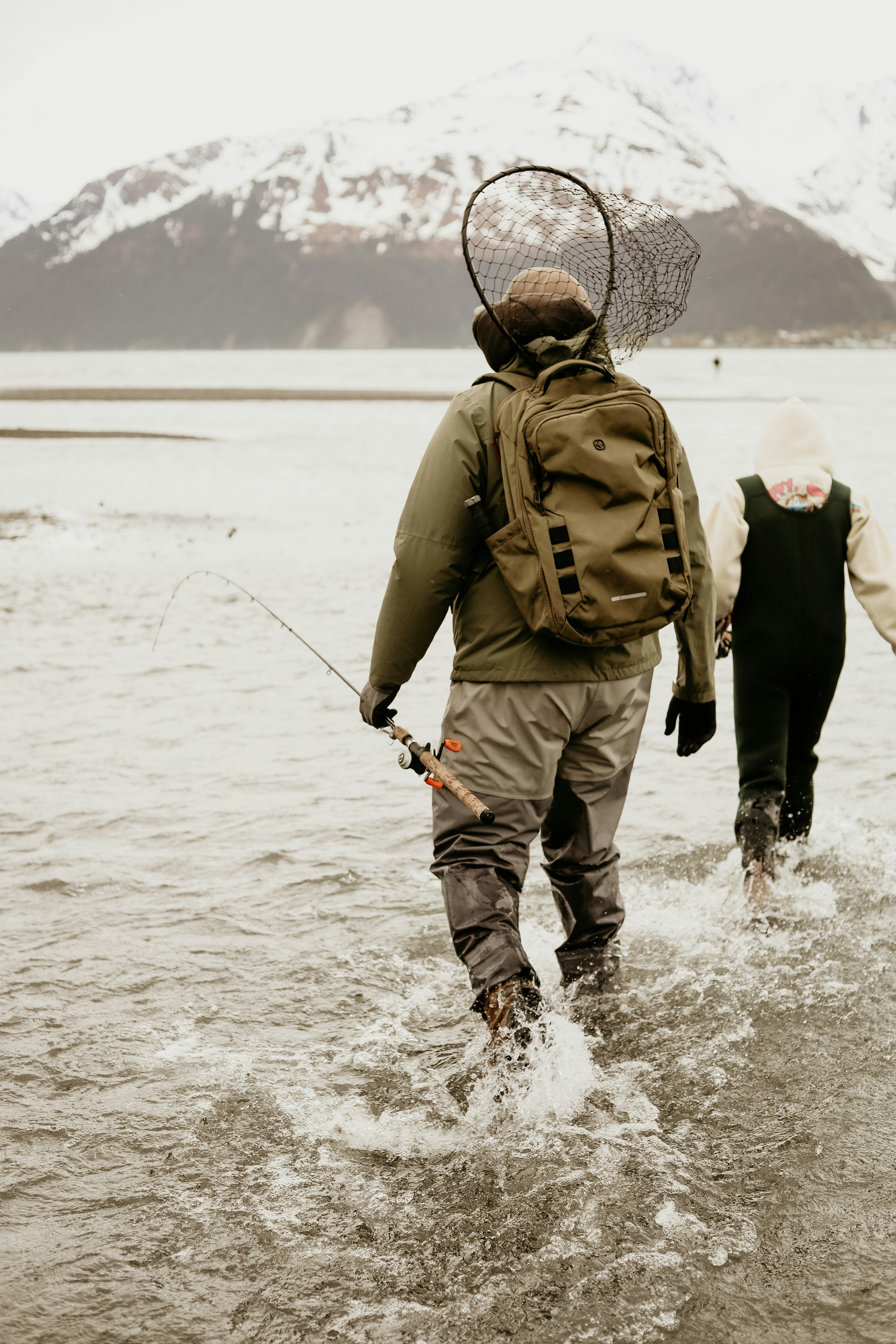 A couple of people walking across a river
