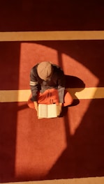 A person sitting on the floor reading a book