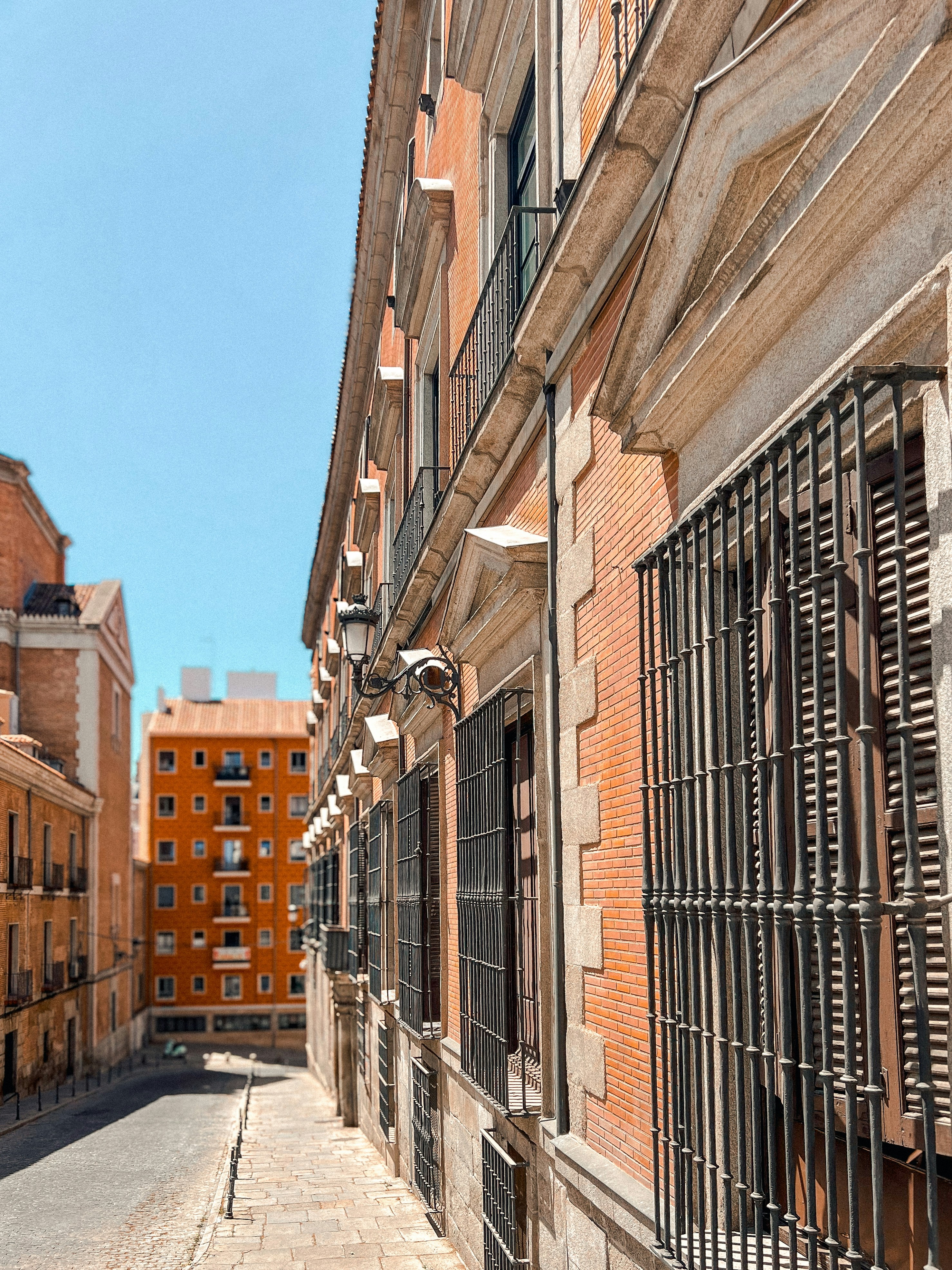 A narrow city street lined with tall brick buildings photo – Free ...