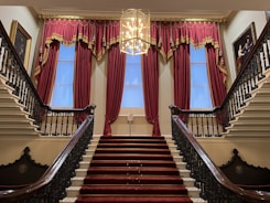 A staircase with a chandelier and a chandelier hanging from the ceiling