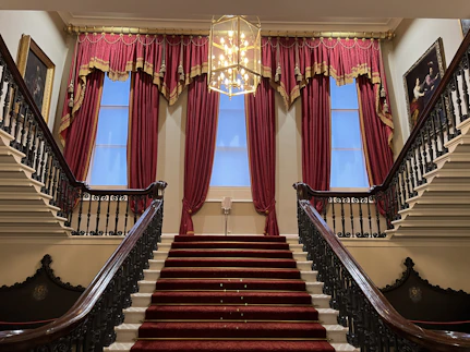A staircase with a chandelier and a chandelier hanging from the ceiling