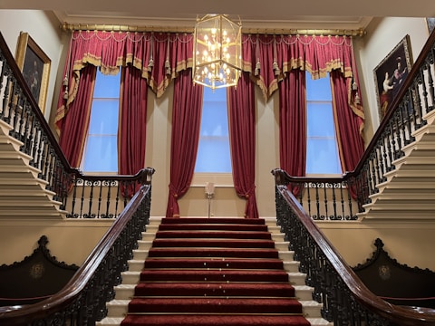 A staircase with a chandelier and a chandelier hanging from the ceiling