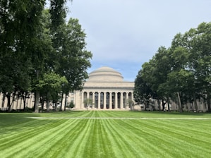 A large grassy field with a building in the background