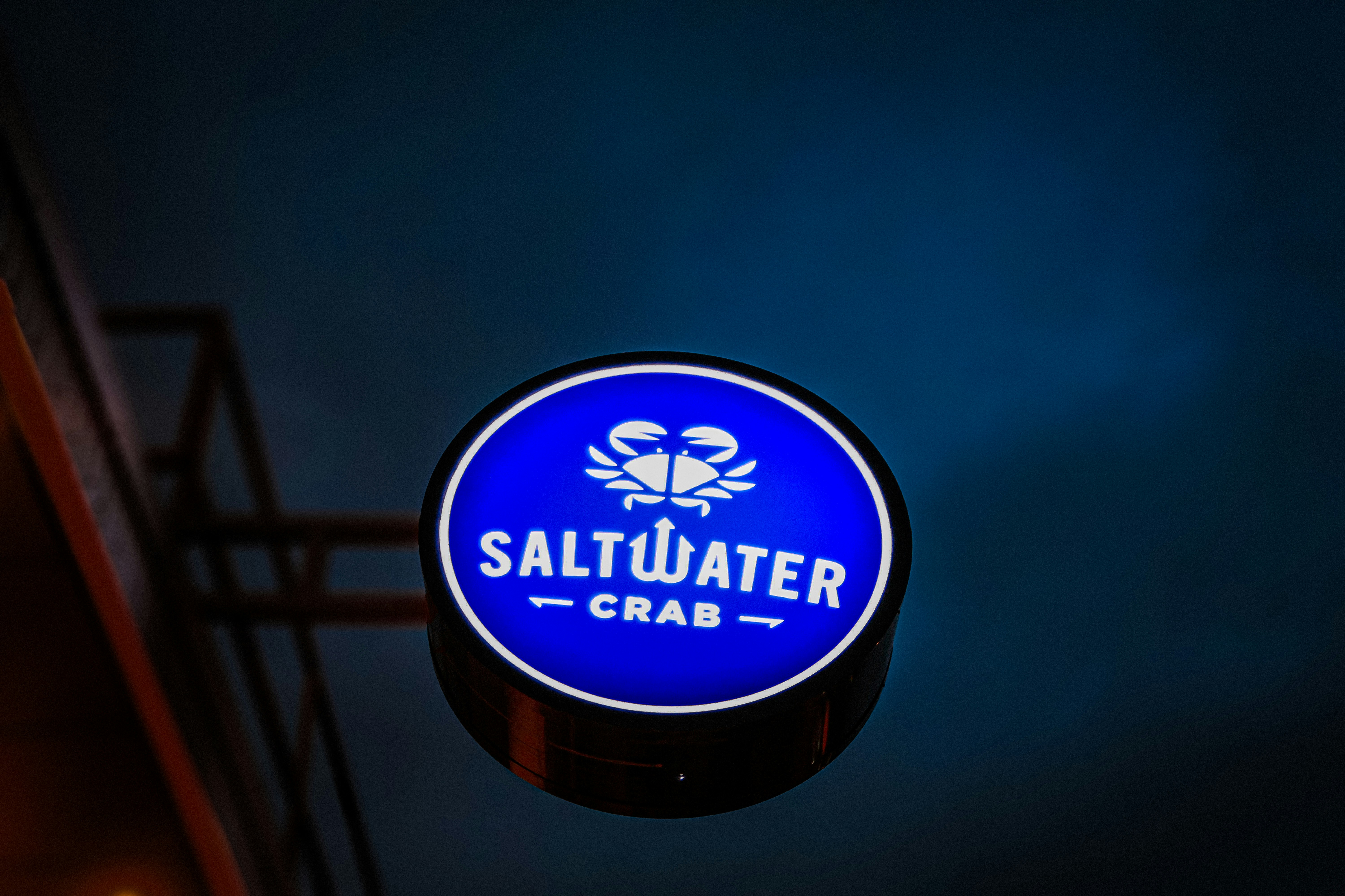 A blue sign hanging from the side of a building