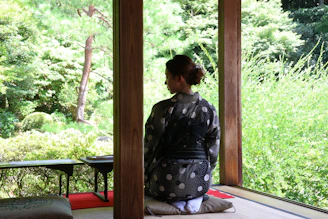 A woman sitting on a mat in a room