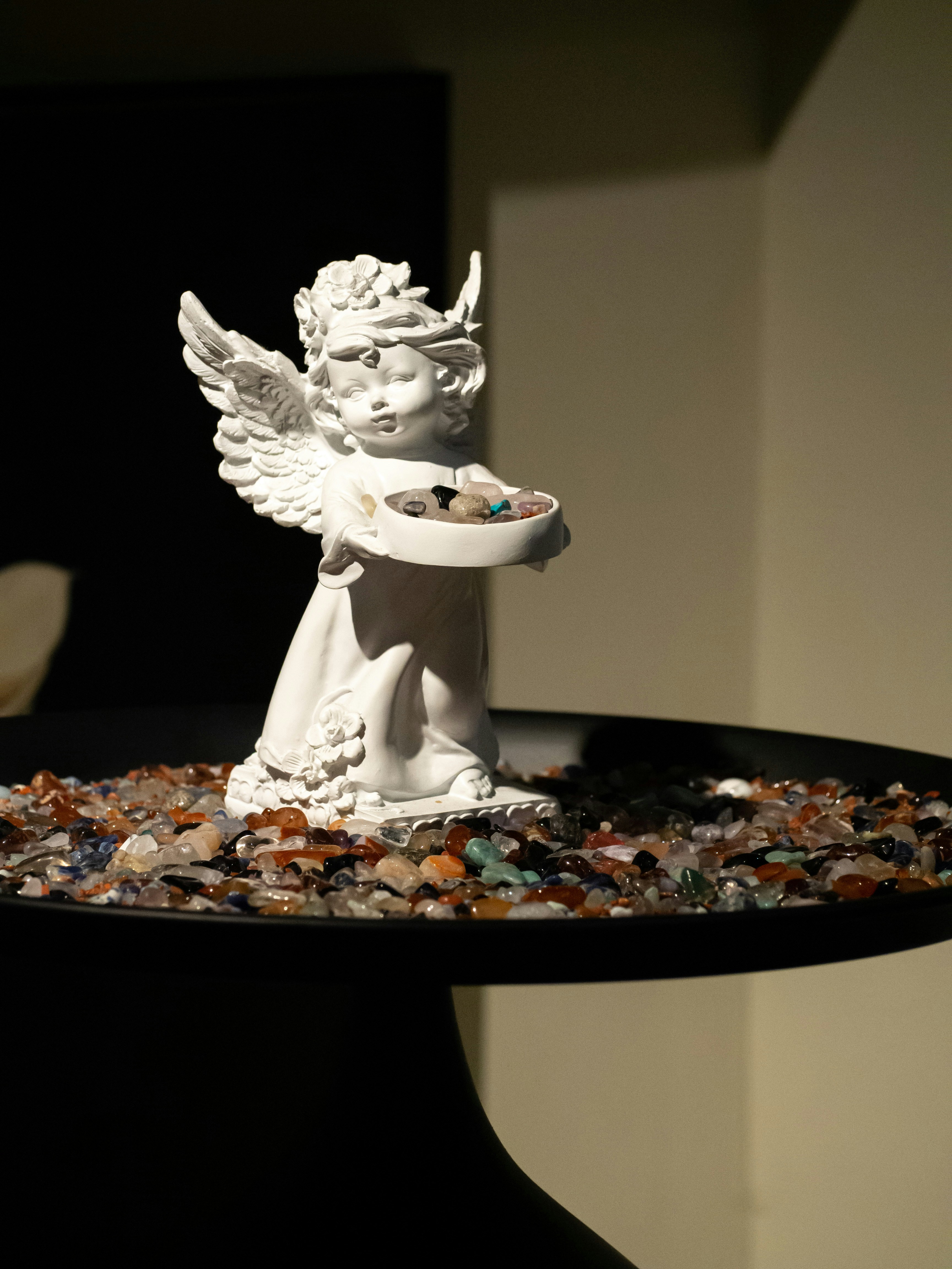 A statue of an angel holding a bowl of candy