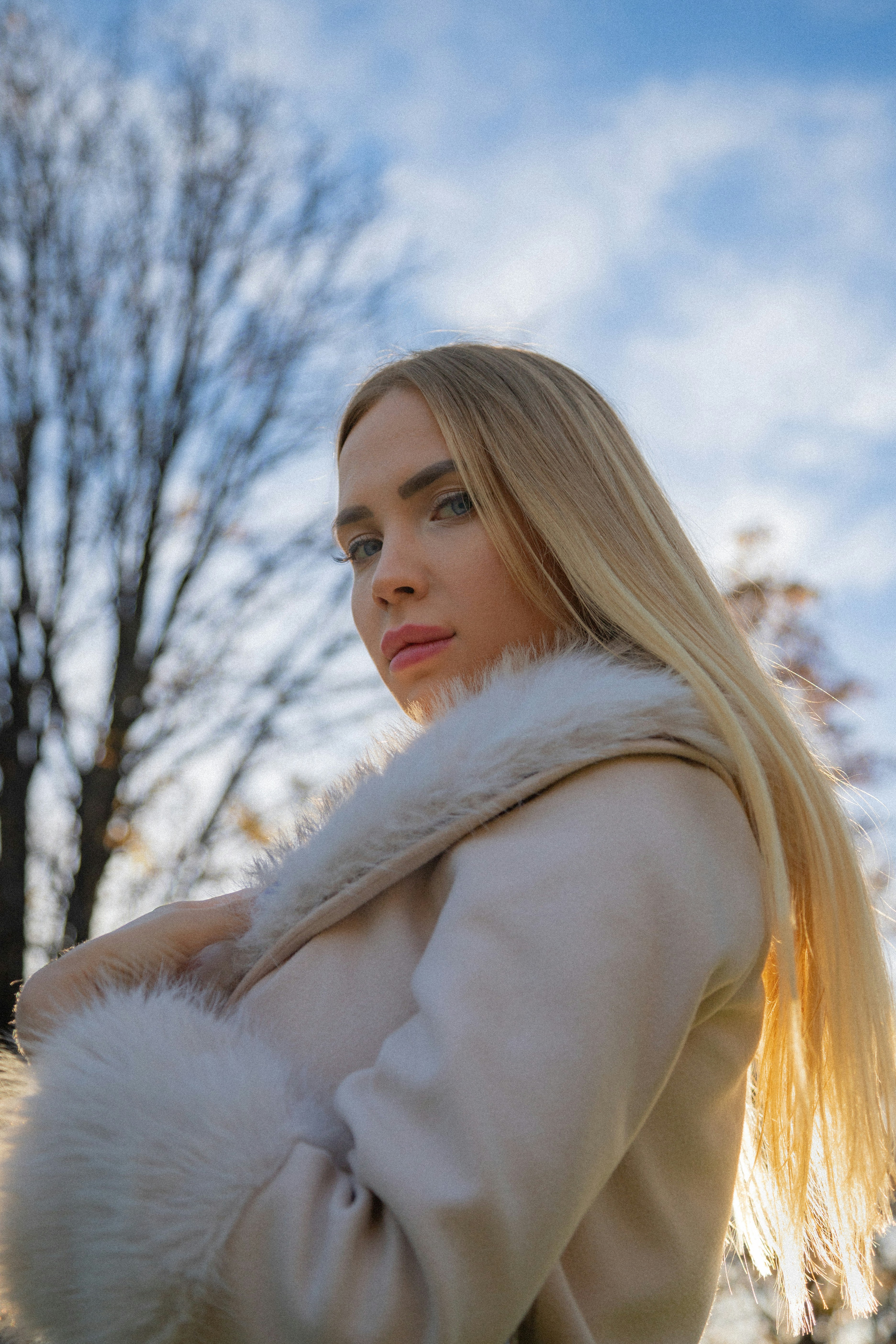 A woman with long blonde hair wearing a white coat