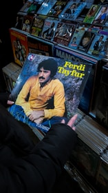 A person holding up a record in front of a wall of records