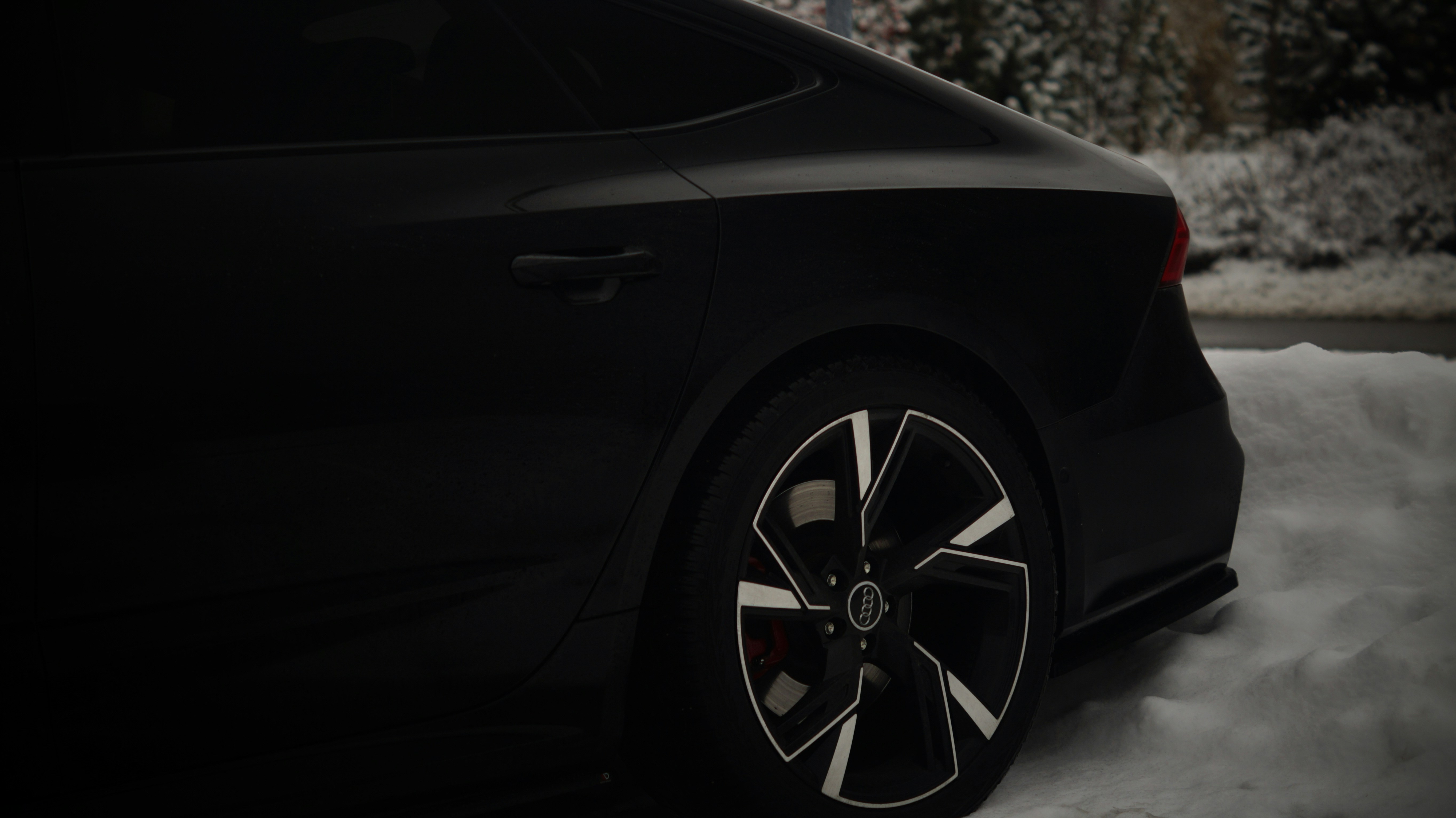 A black car is parked in the snow