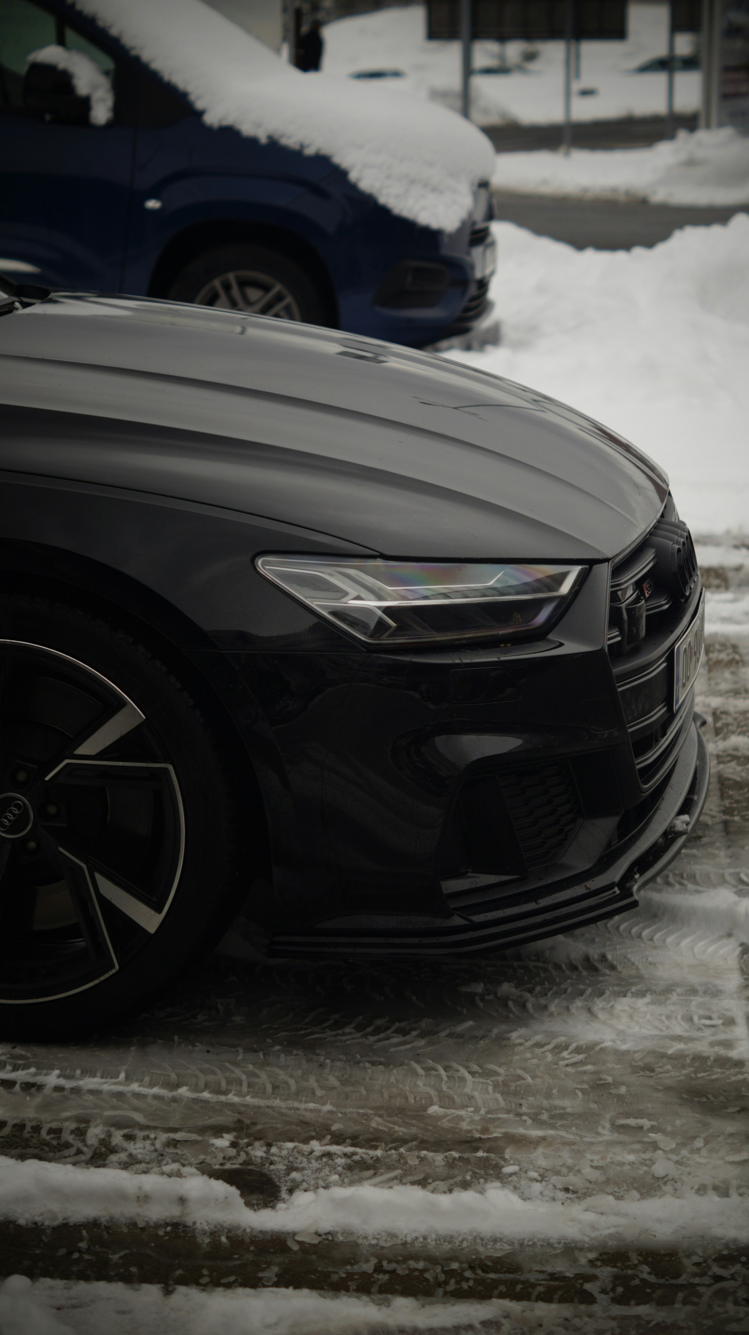 A car parked on a snowy street next to another car