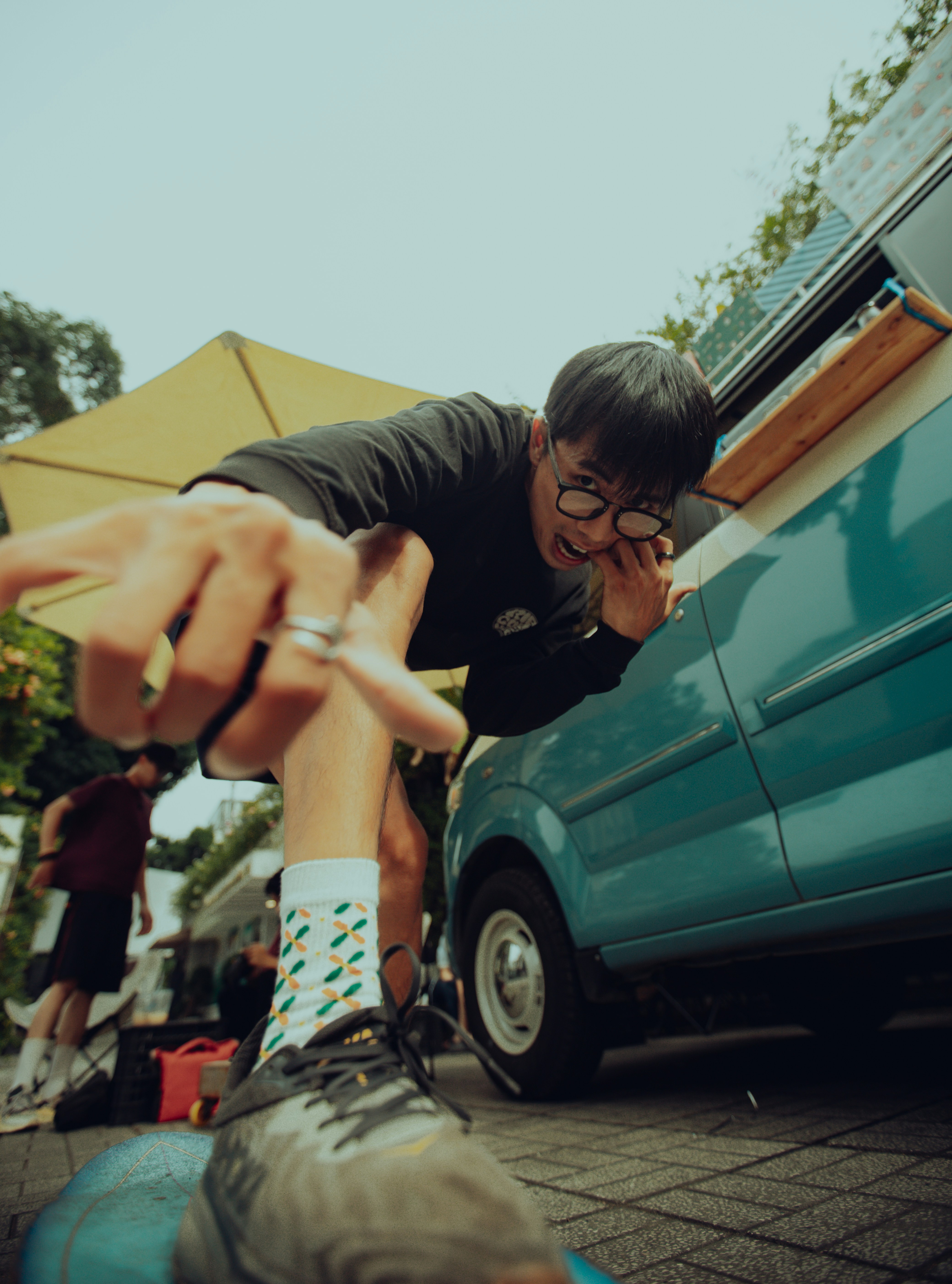 Seorang pria bersandar di atas van biru di pinggir jalan