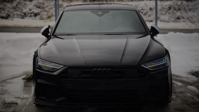 A black car parked in a parking lot