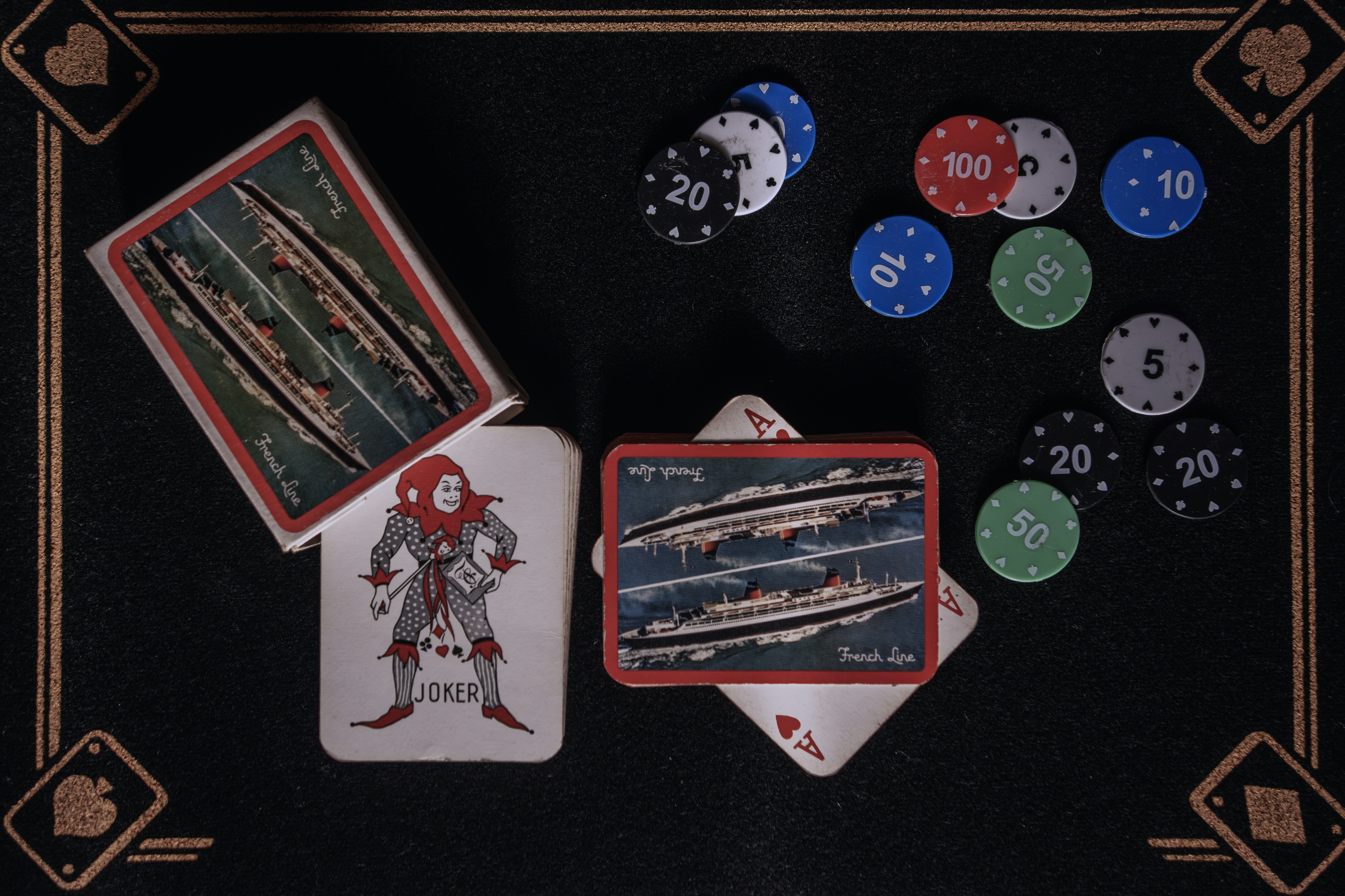 A black table topped with playing cards and poker chips