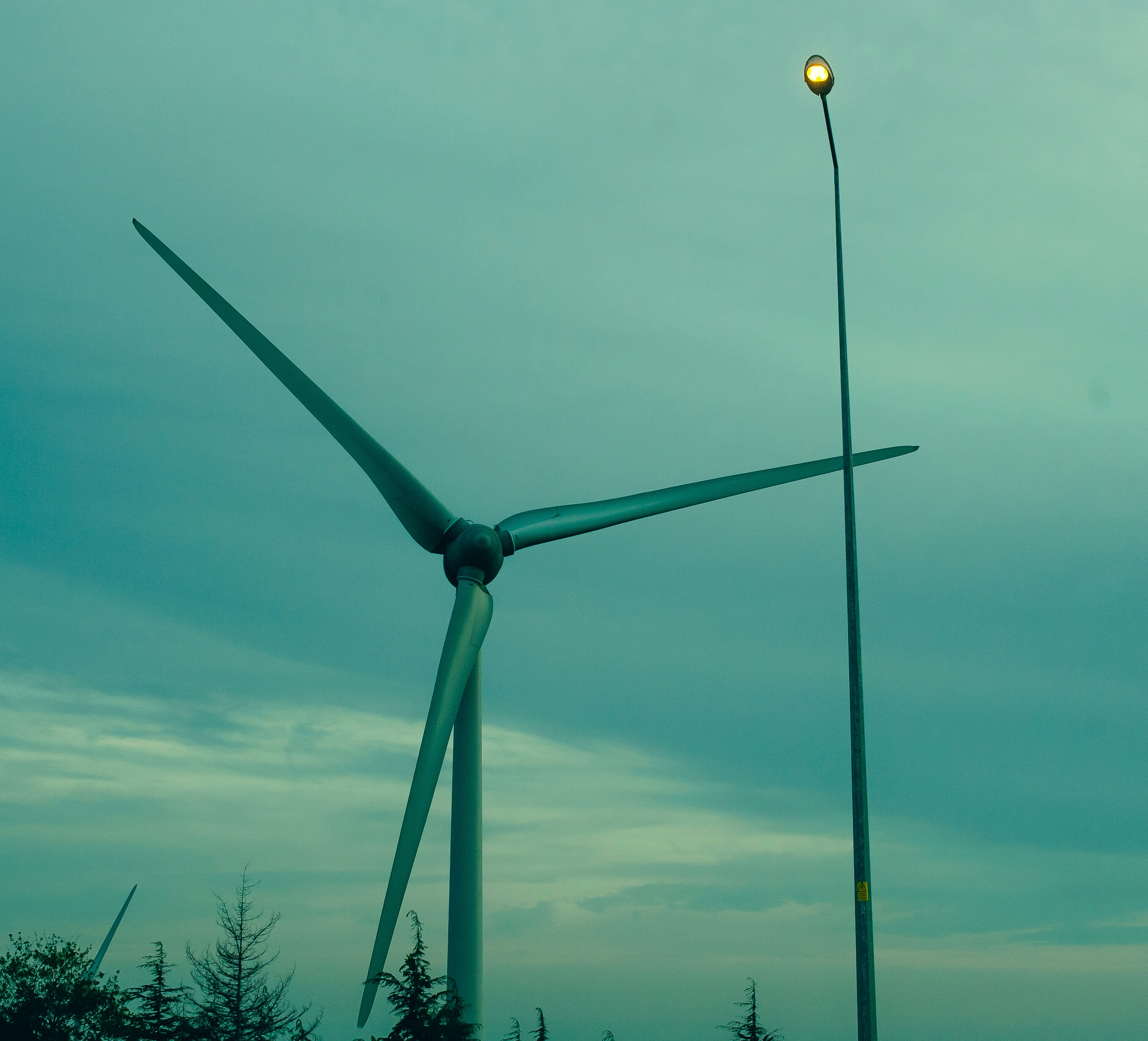 A wind turbine sitting next to a street light