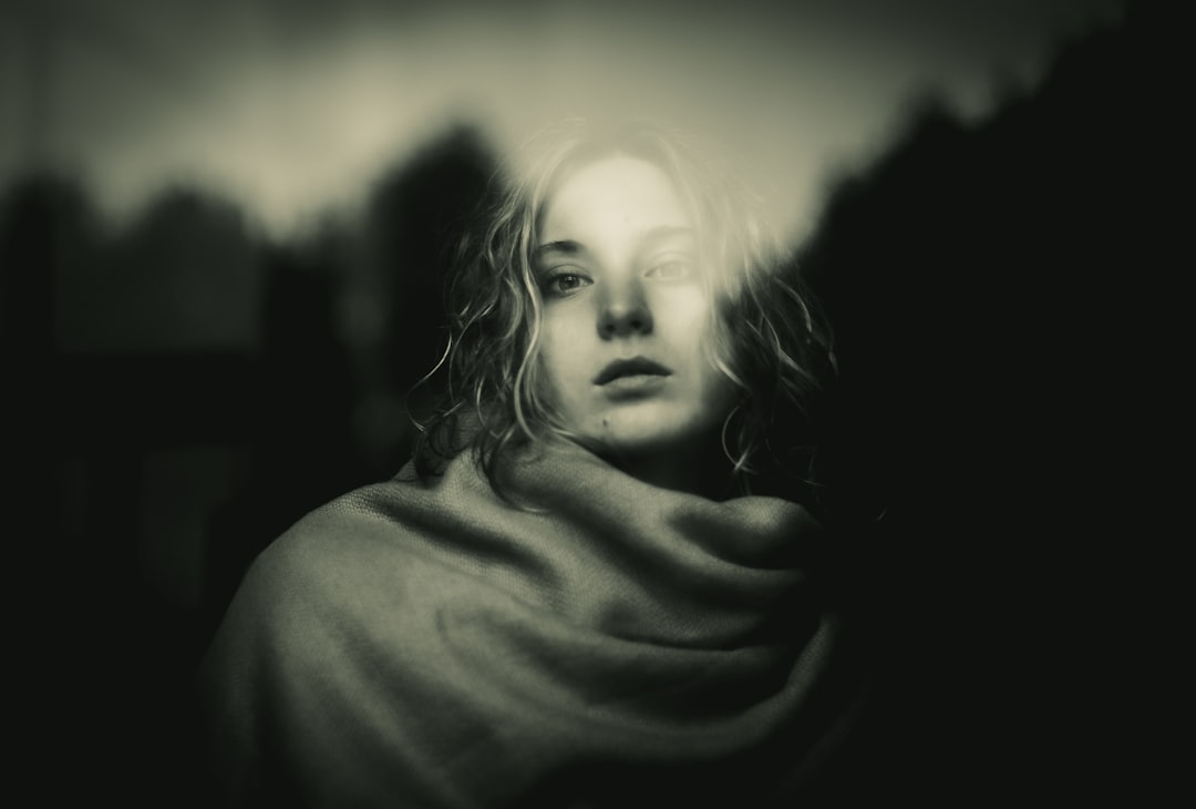 A black and white photo of a woman wrapped in a blanket,