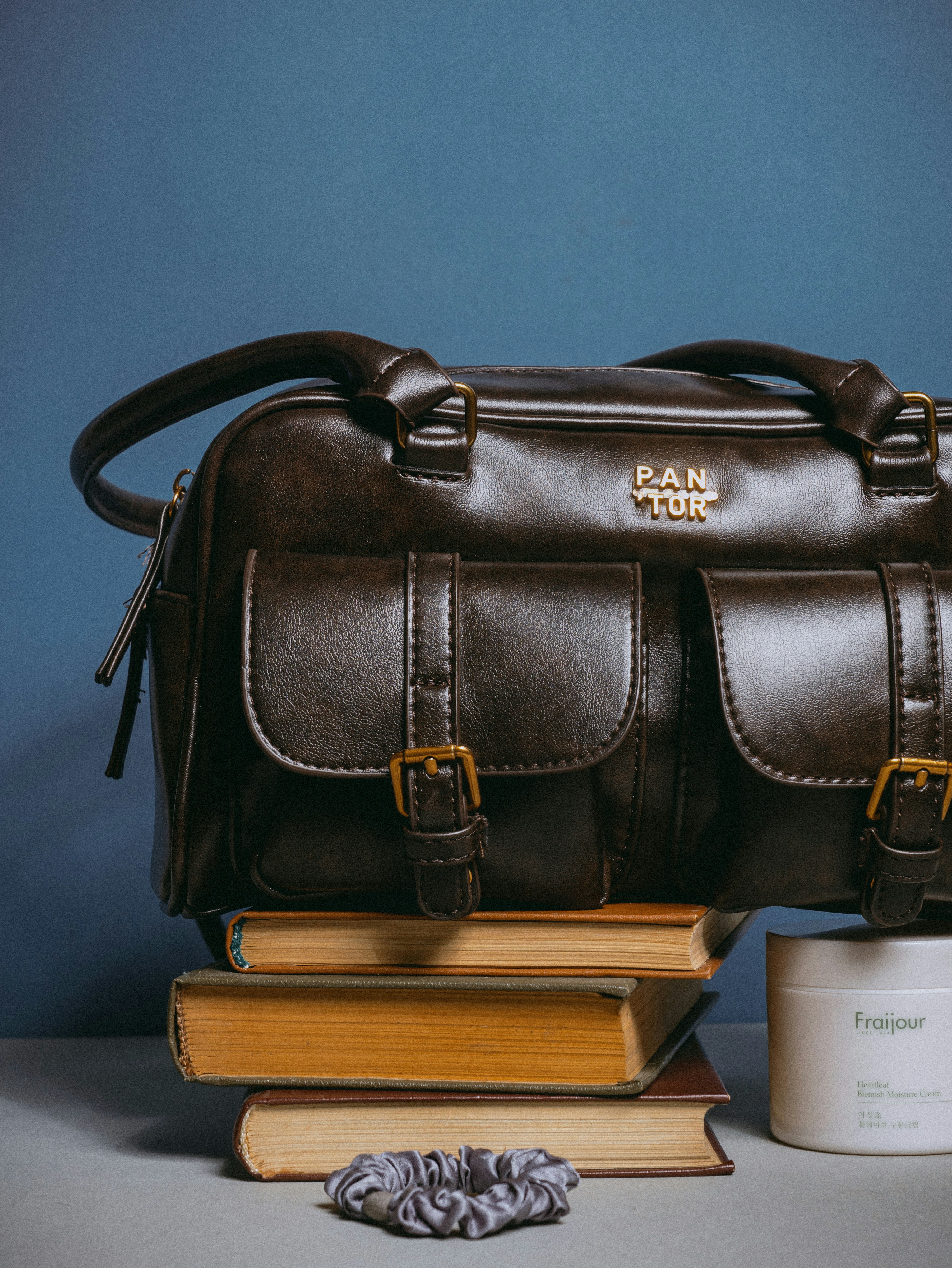 A brown bag sitting on top of a stack of books