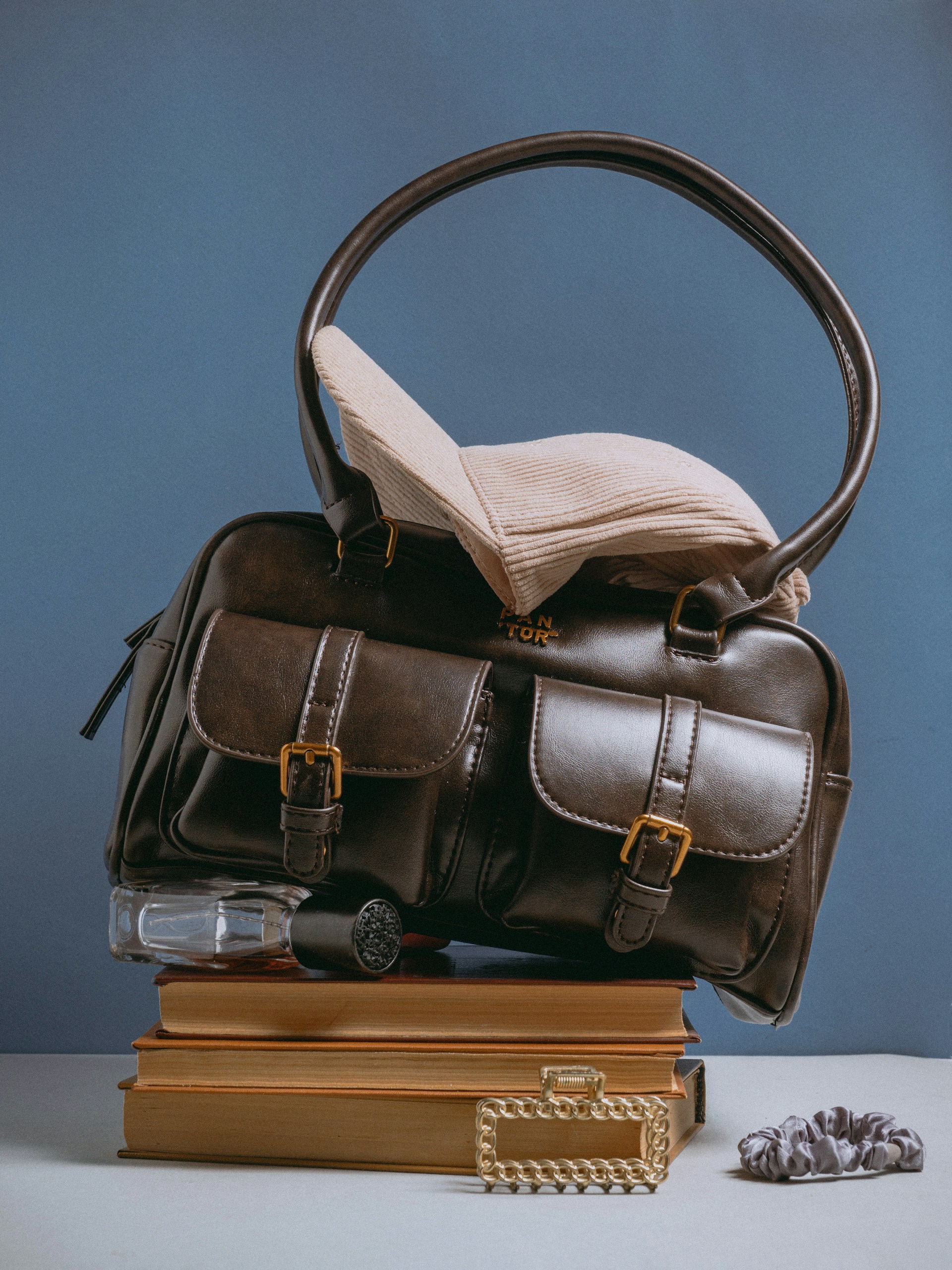 A brown bag sitting on top of a pile of books
