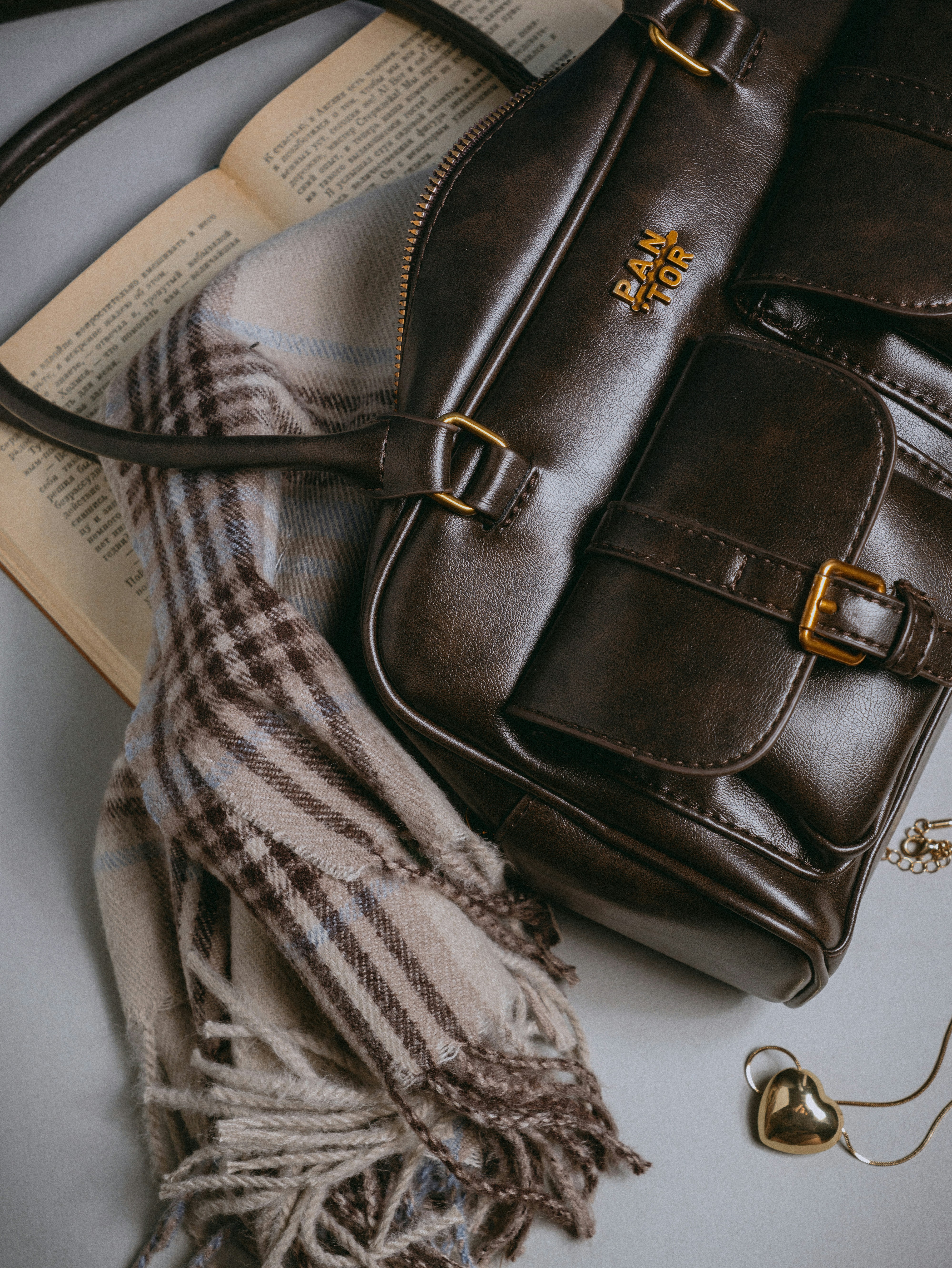 A brown purse sitting on top of an open book