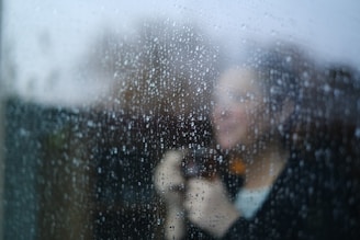 A blurry image of a woman looking out a window