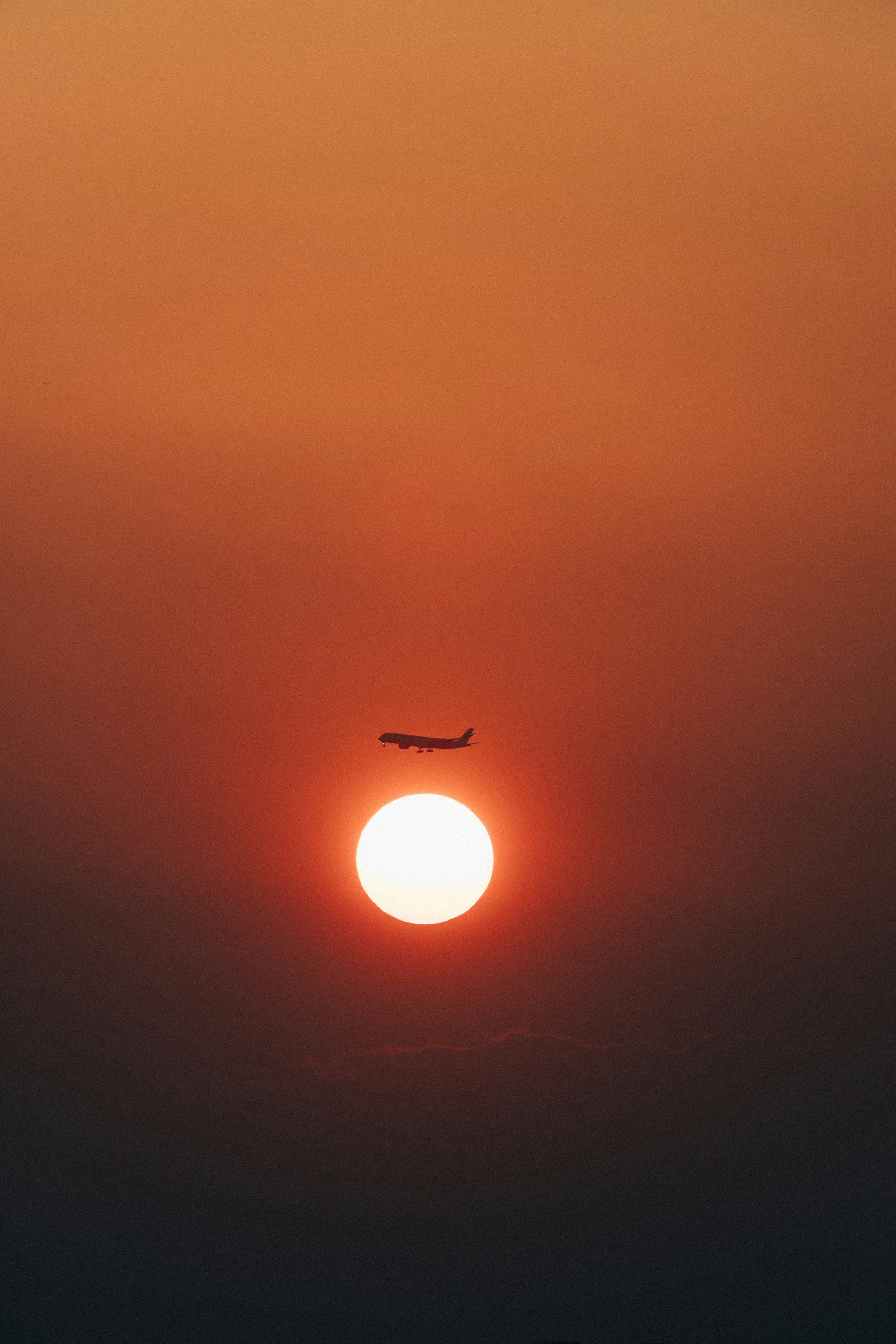 A plane flying in the sky at sunset photo – Free Japan Image on Unsplash