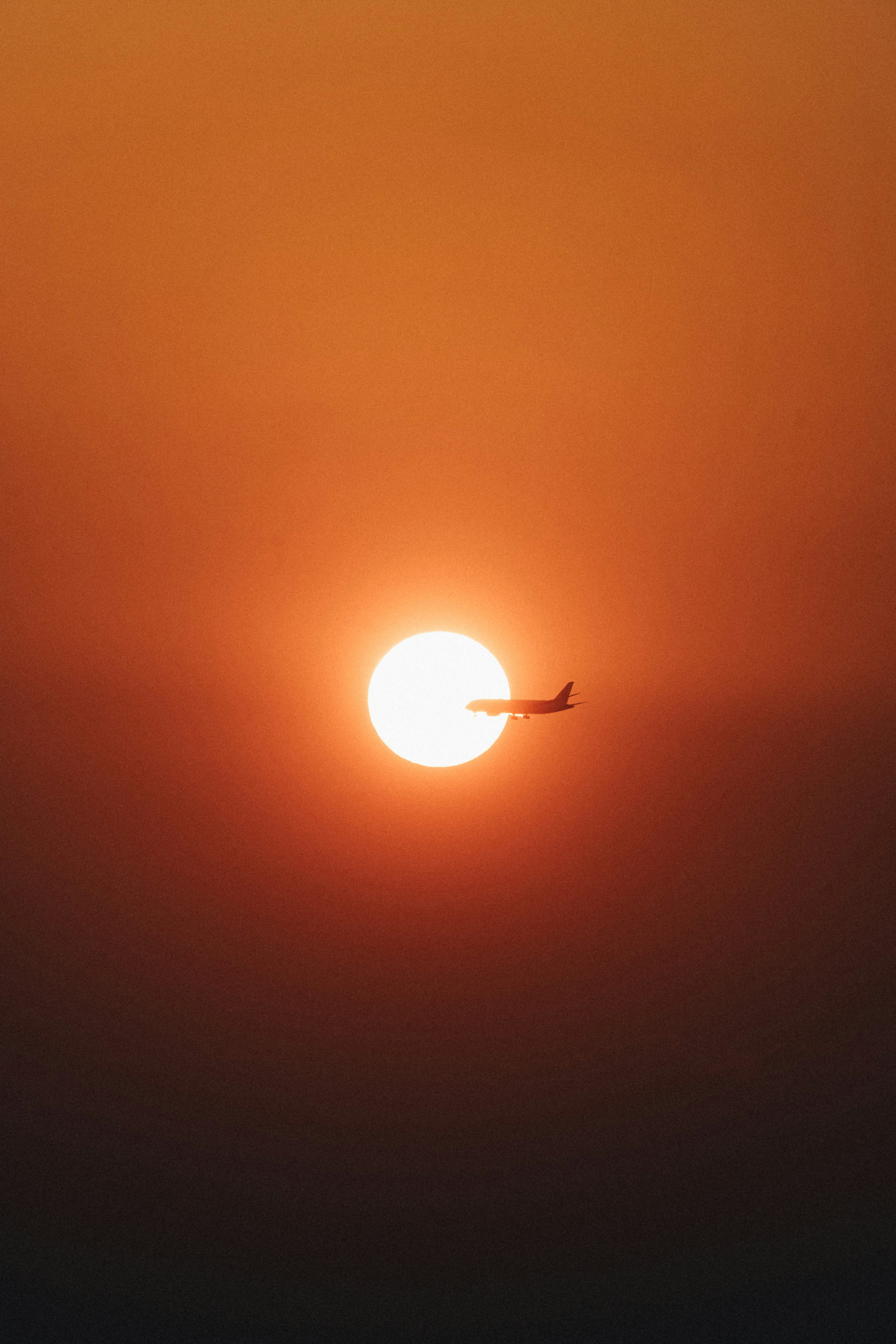 A plane flying in the sky at sunset photo – Free Sky Image on Unsplash