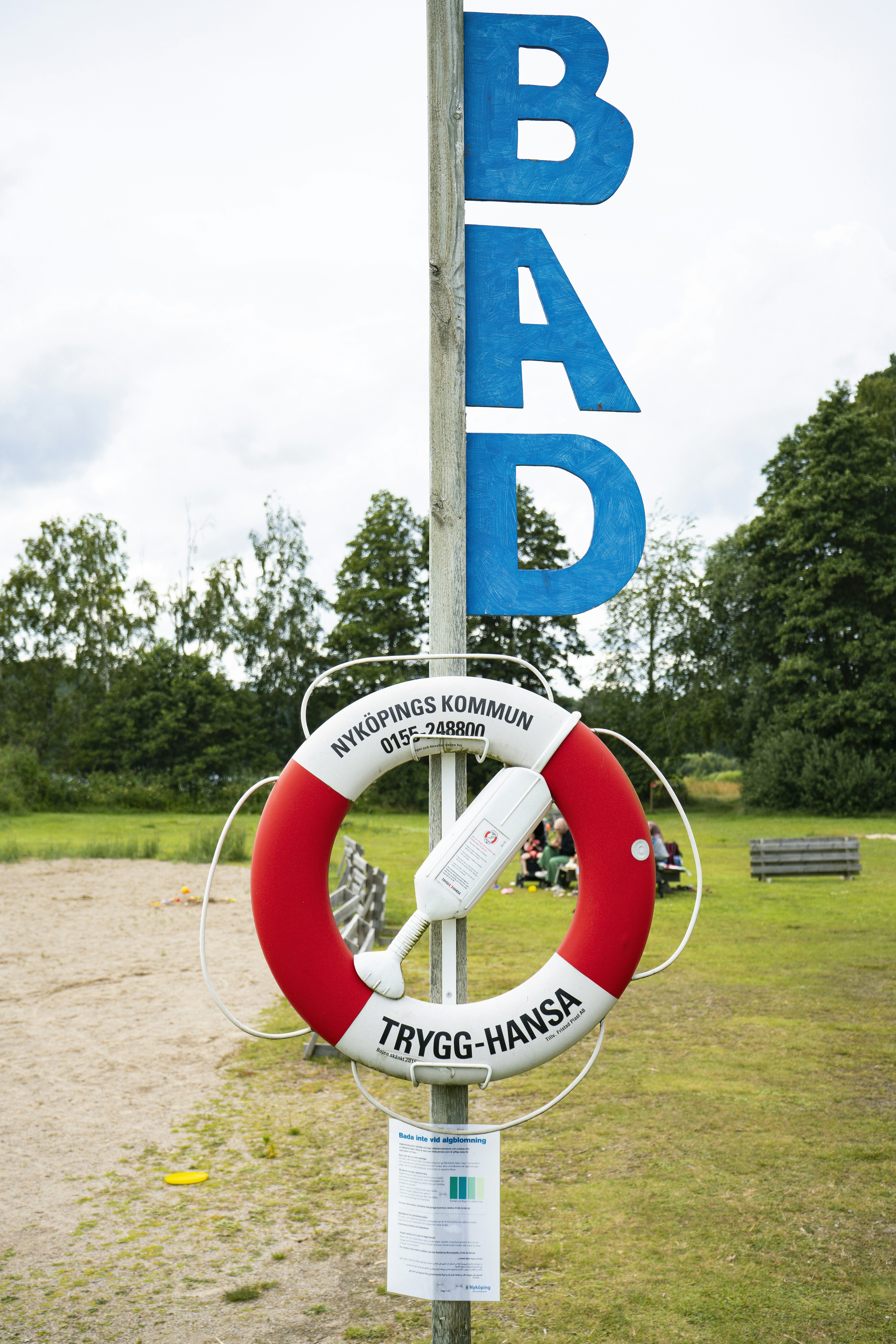 A sign with a life preserver attached to it photo – Free Human Image on ...