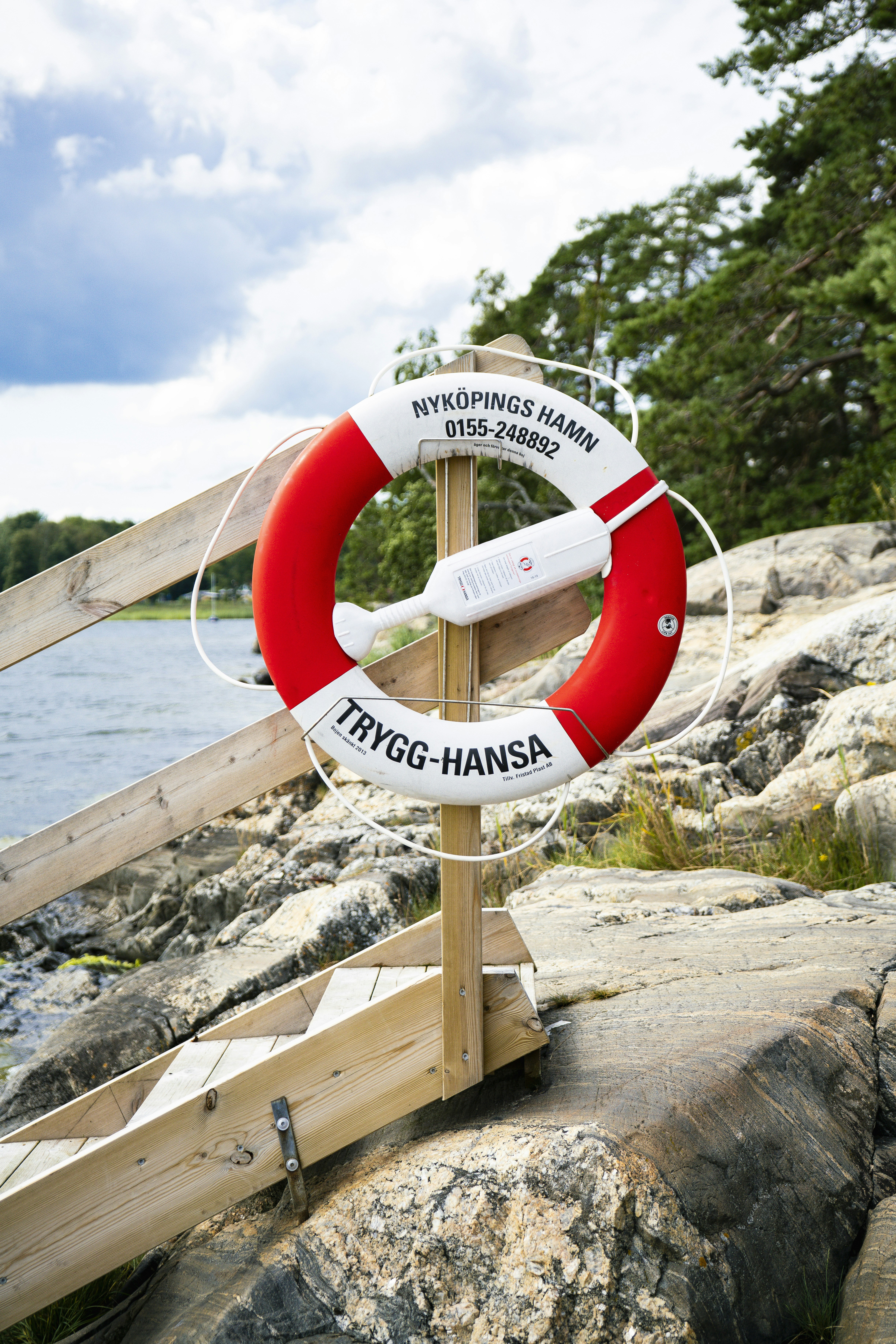 A red and white life preserver sitting on top of a rock