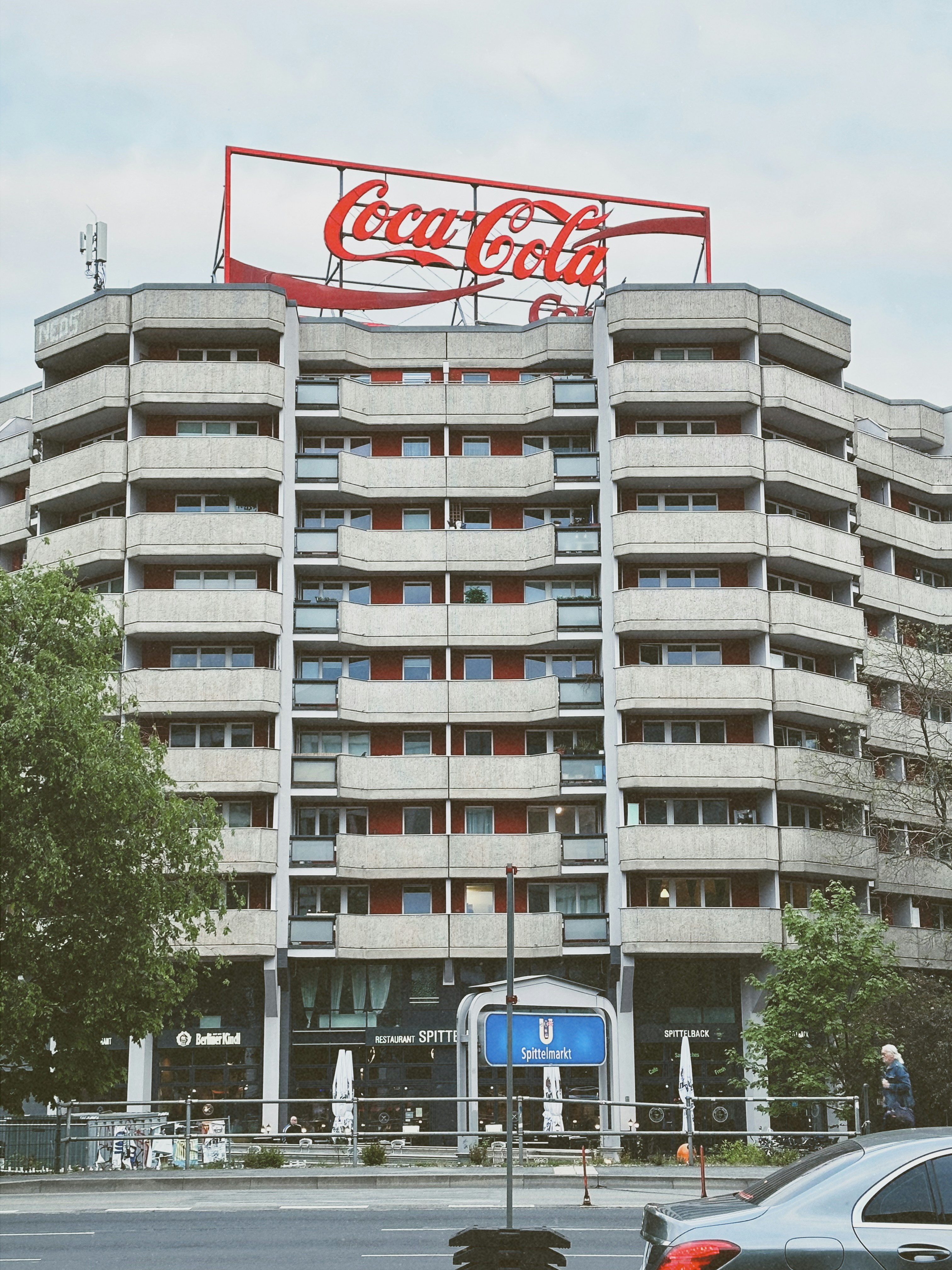 A tall building with a coca cola sign on top of it
