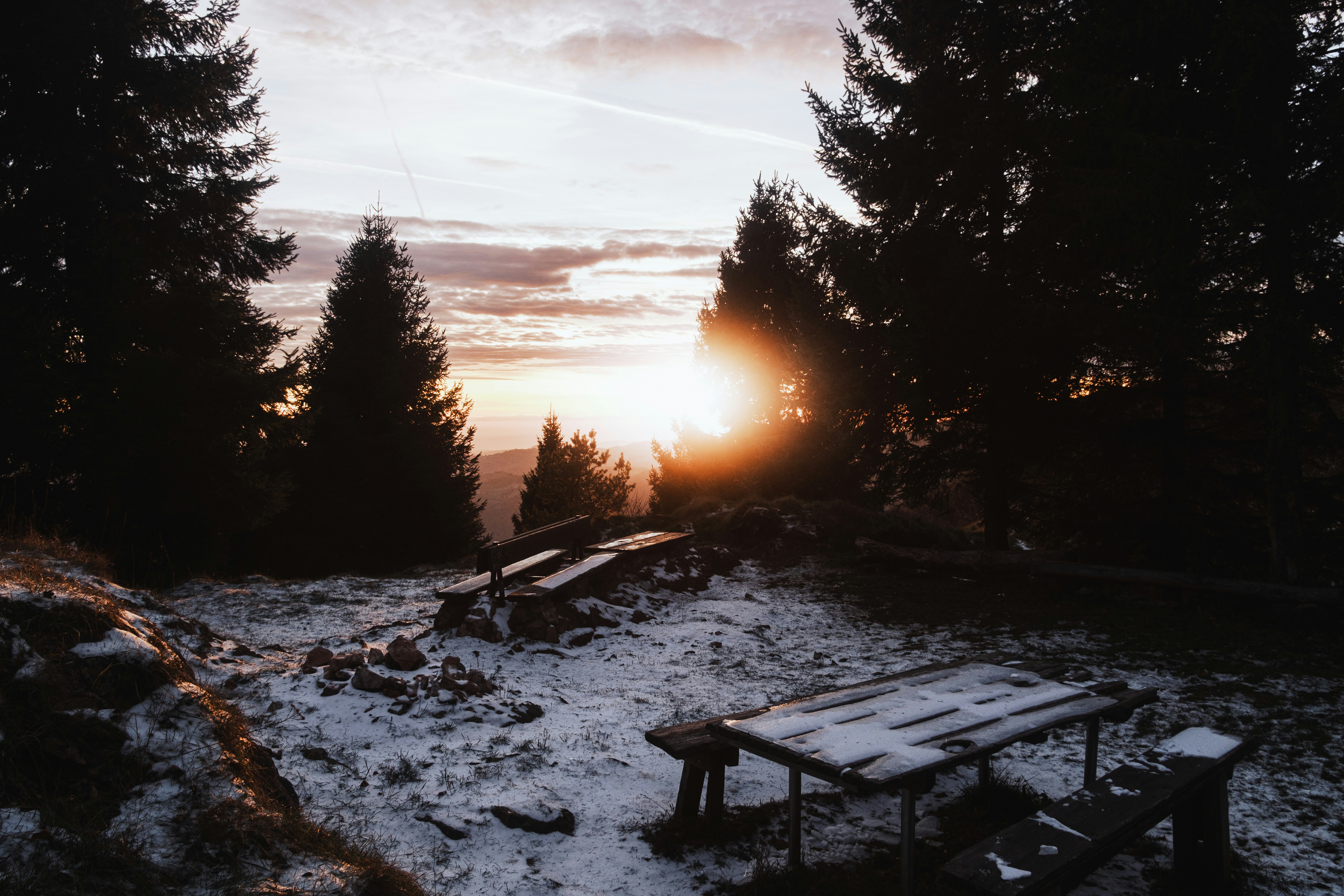 A bench sitting on top of a snow covered field