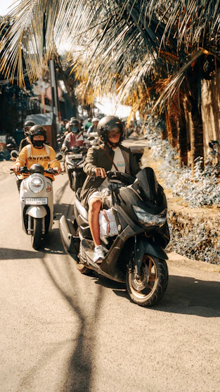 A group of people riding motorcycles down a street