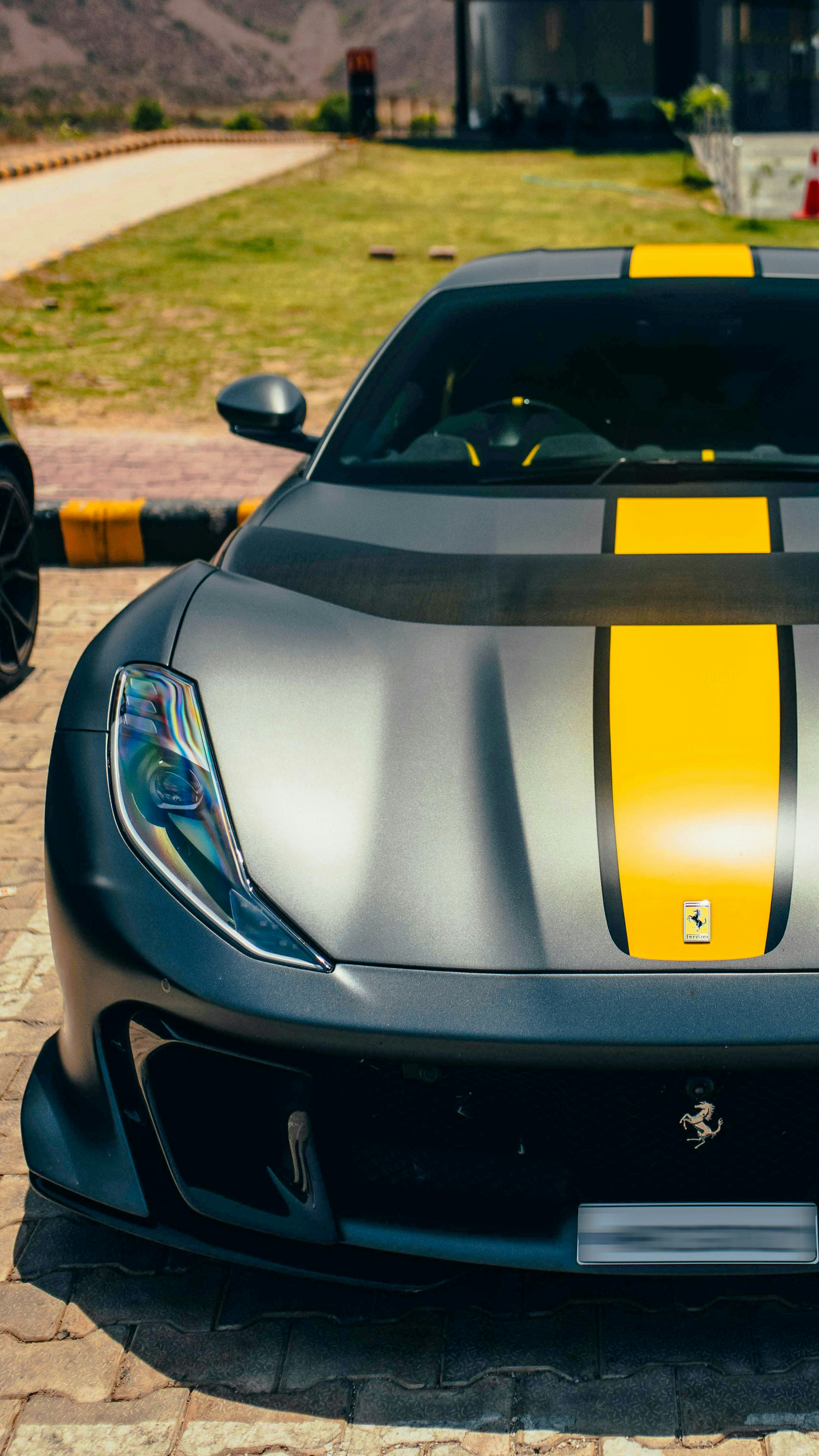 Un'auto sportiva nera e gialla parcheggiata in un vialetto