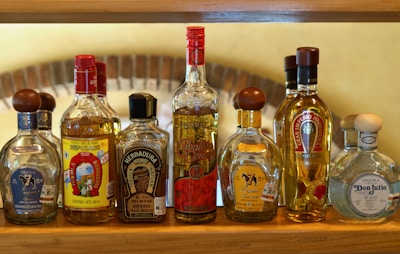 A wooden shelf filled with bottles of liquor