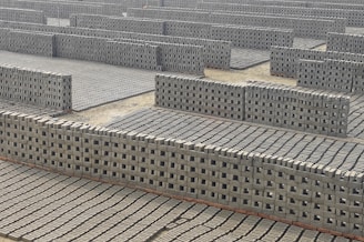 A large group of cinder blocks sitting on top of a cement floor