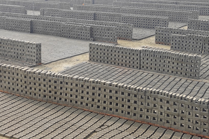 A large group of cinder blocks sitting on top of a cement floor