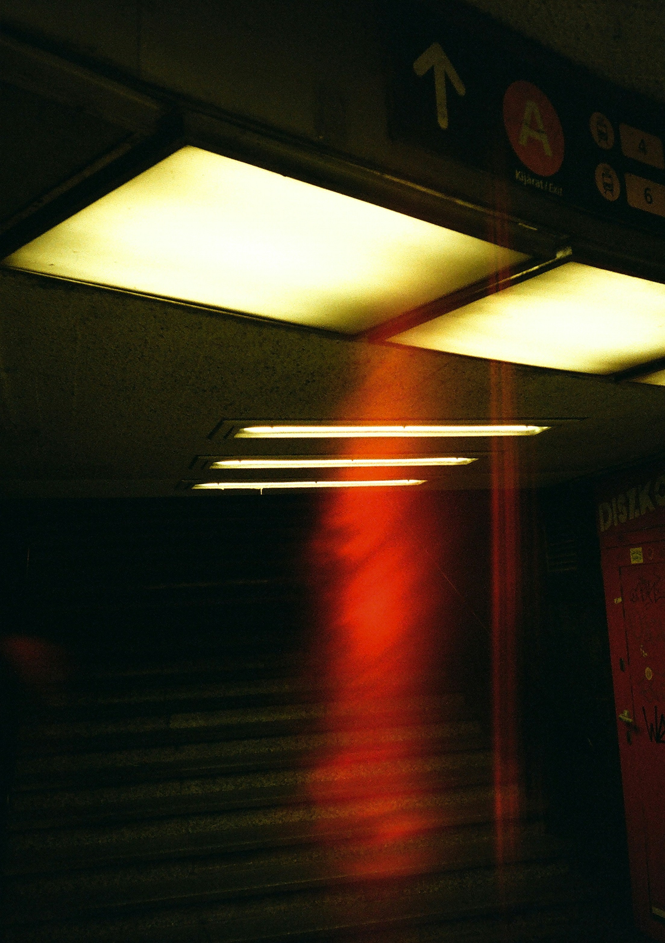 A red light shines brightly on a subway platform