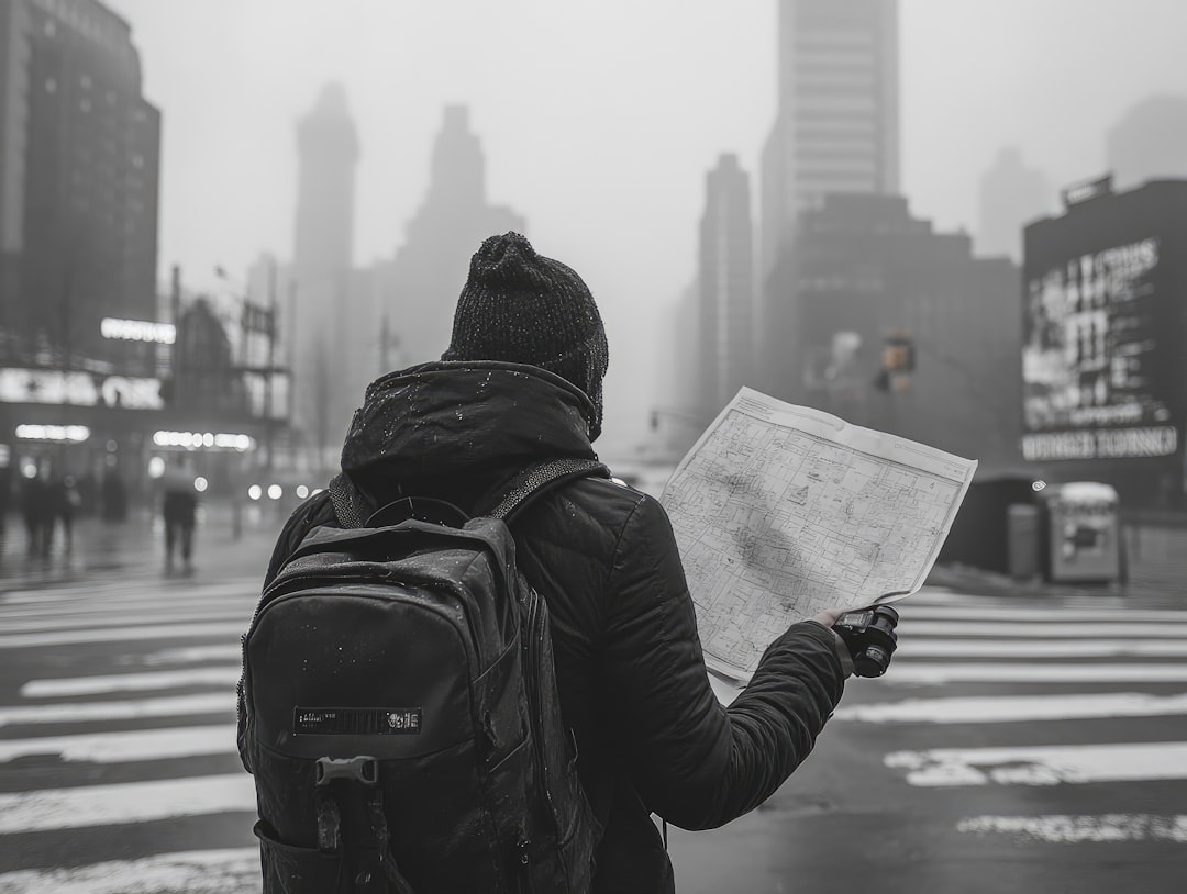 A person with a backpack looking at a map,