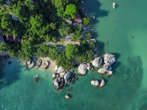 An aerial view of a beach with rocks and water
