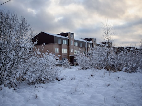 A snow covered field with a building in the background