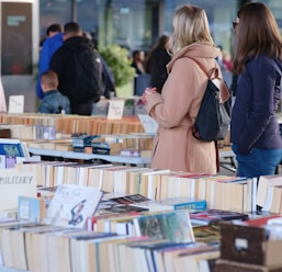 A group of people standing around a table filled with books
