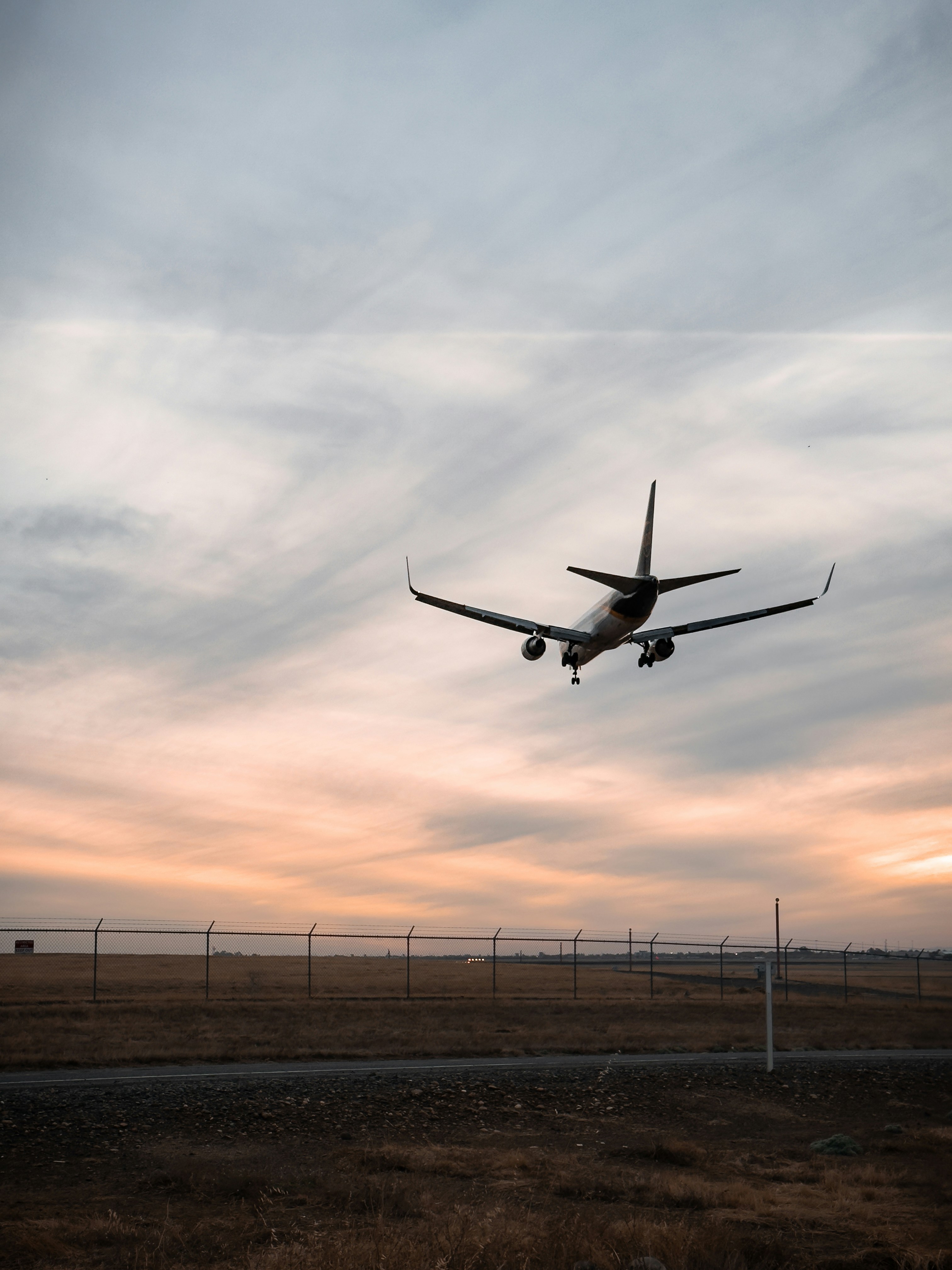 An airplane is flying in the sky over a field