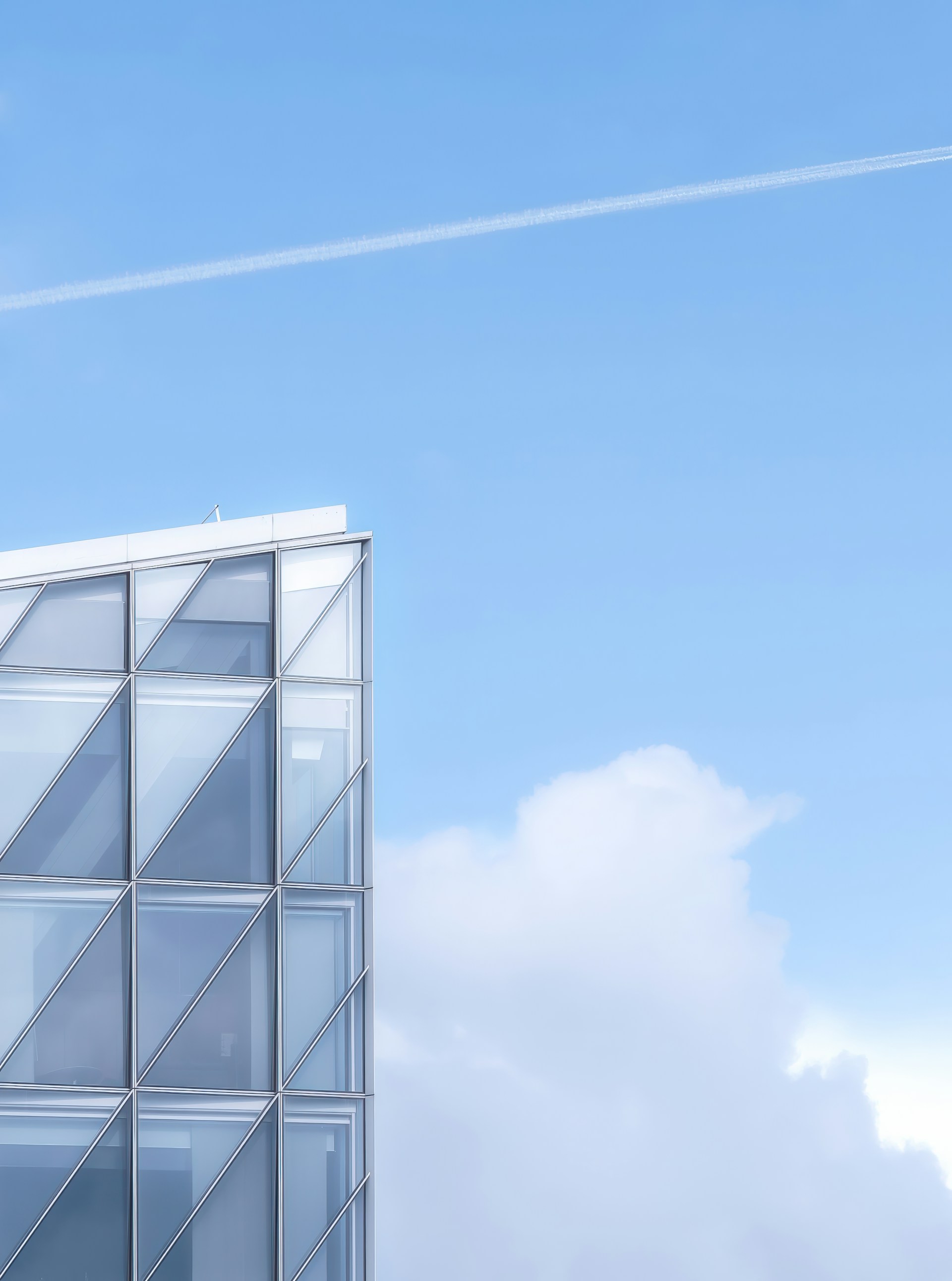 An airplane flying over a tall building with a sky background