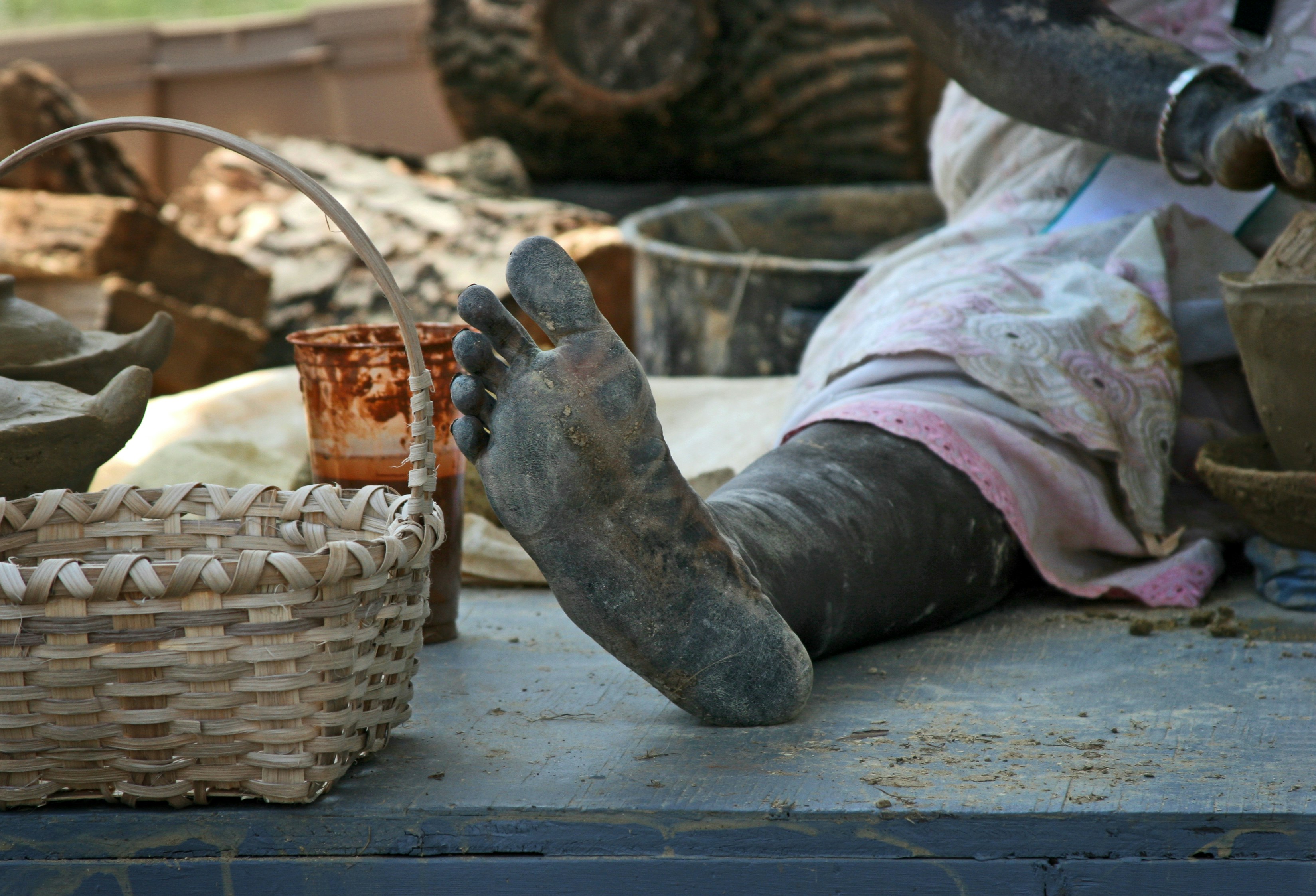 A person sitting on the ground next to a basket