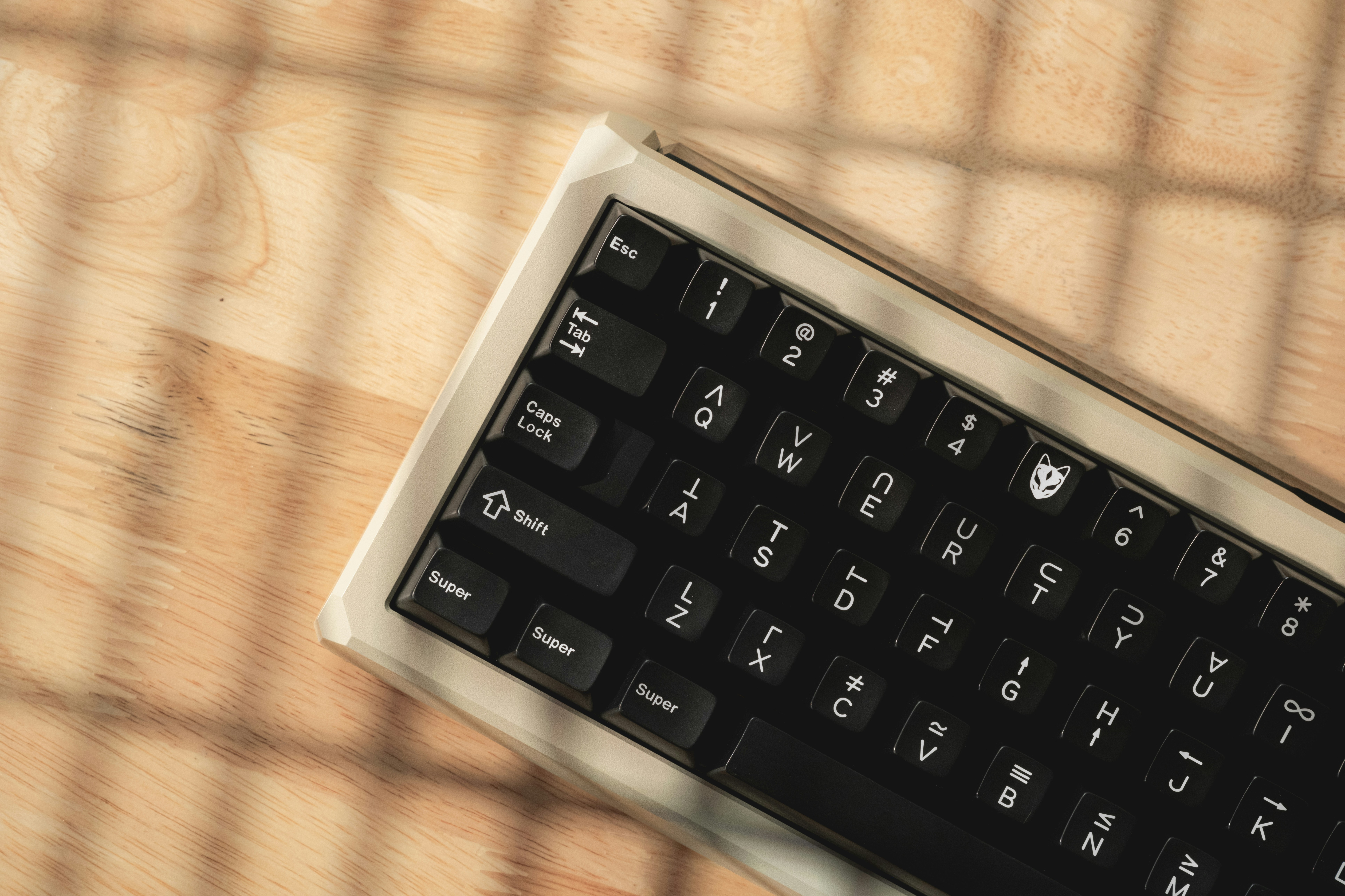 A black keyboard sitting on top of a wooden table