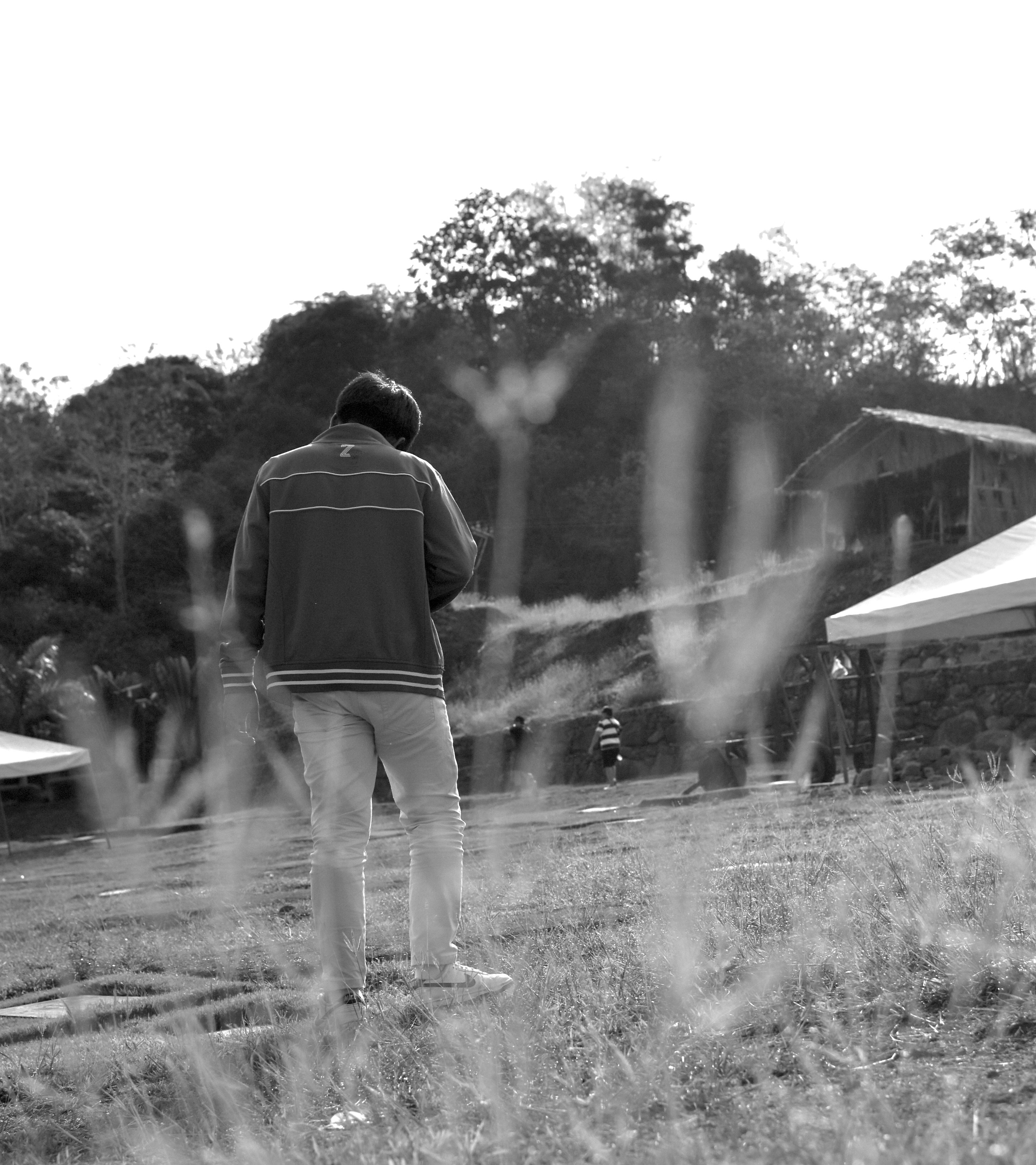 A black and white photo of a man standing in a field
