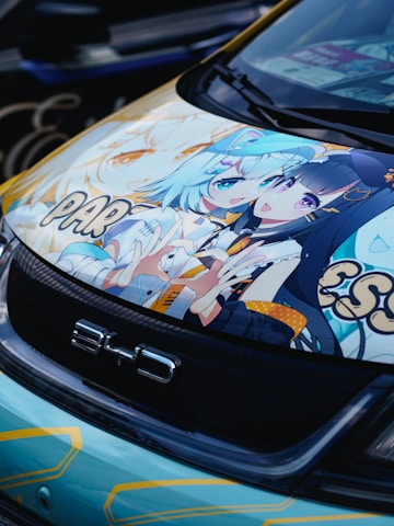 A close up of a parked car with anime characters on it