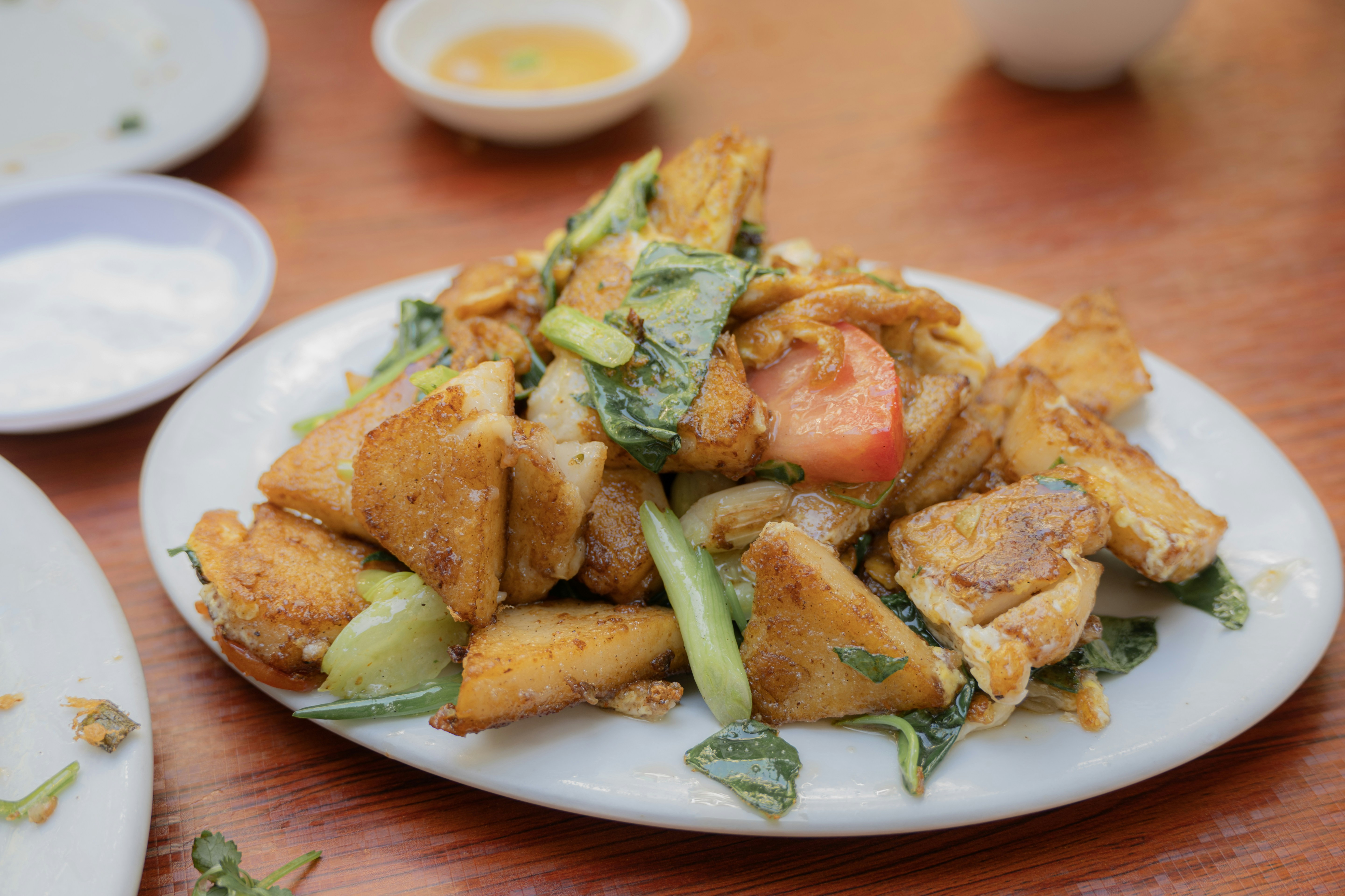 Fried tofu with vegetables on a white plate