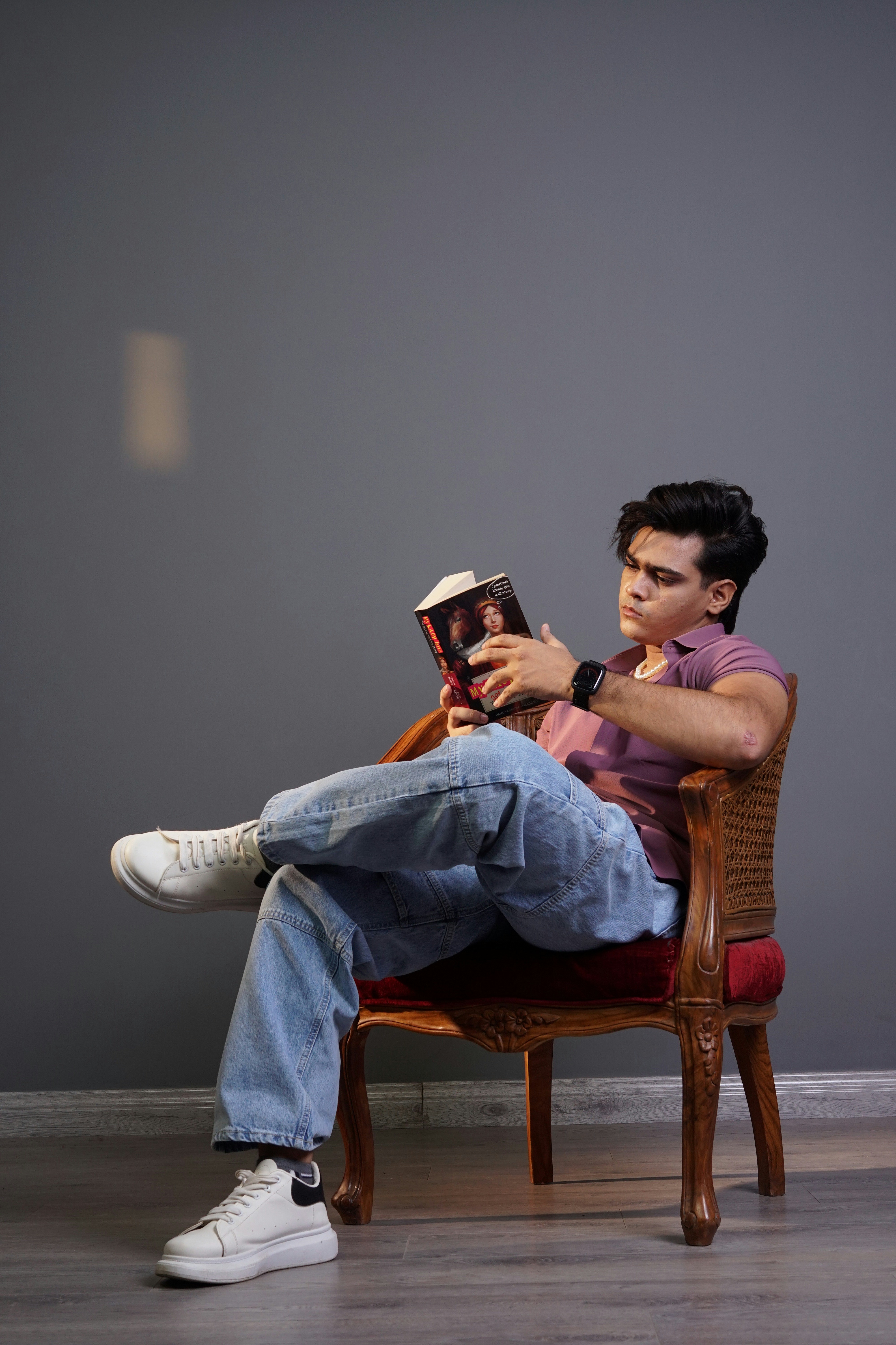 A man sitting in a chair holding a book