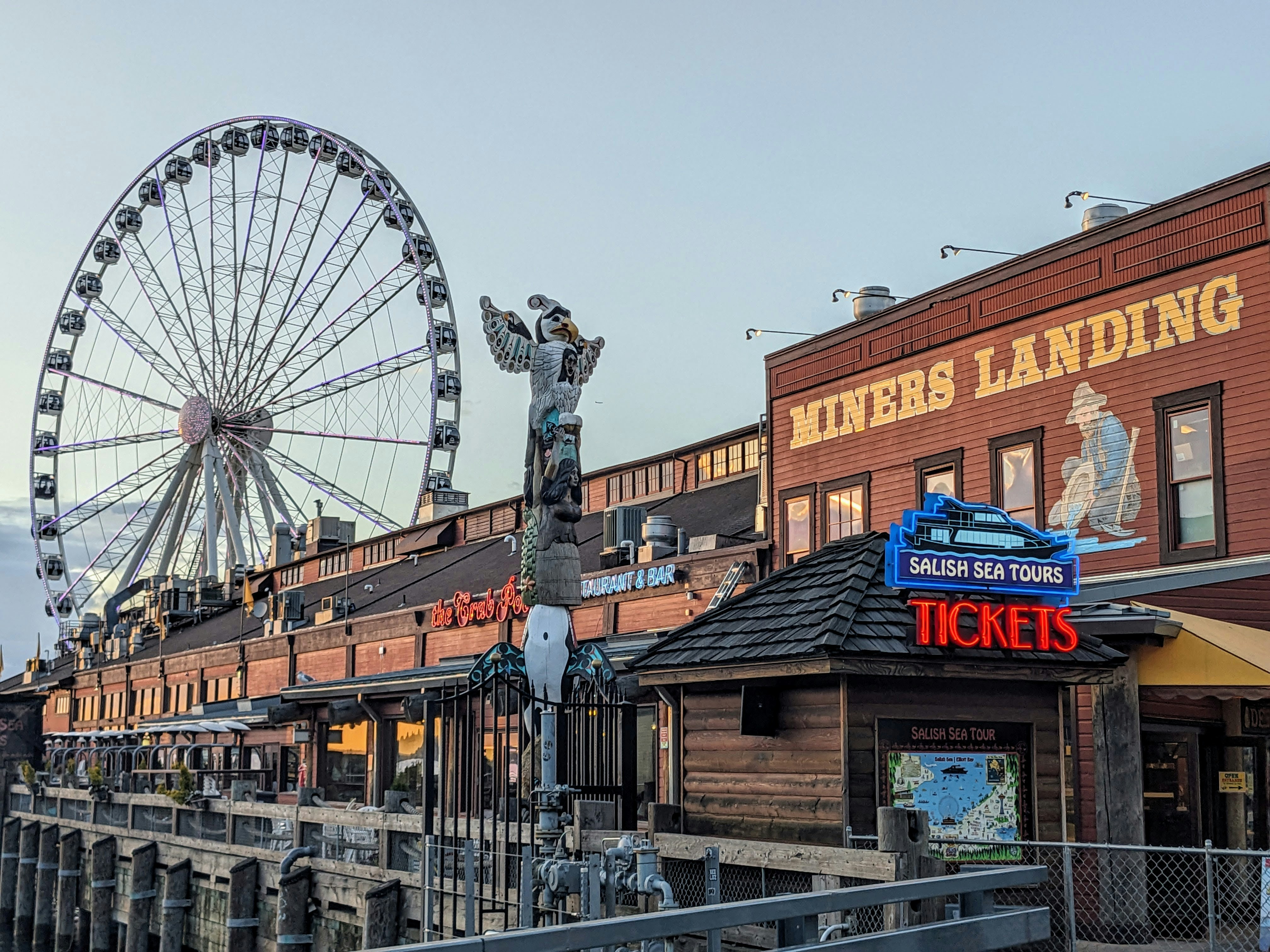 A ferris wheel sitting on top of a pier next to a building