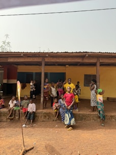 A group of people standing in front of a yellow building